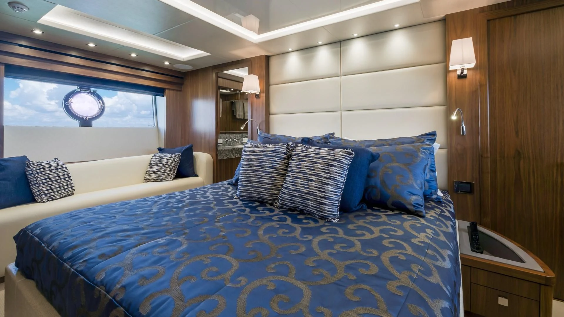 a bed with blue pillows aboard SKYCHASER Yacht for Sale