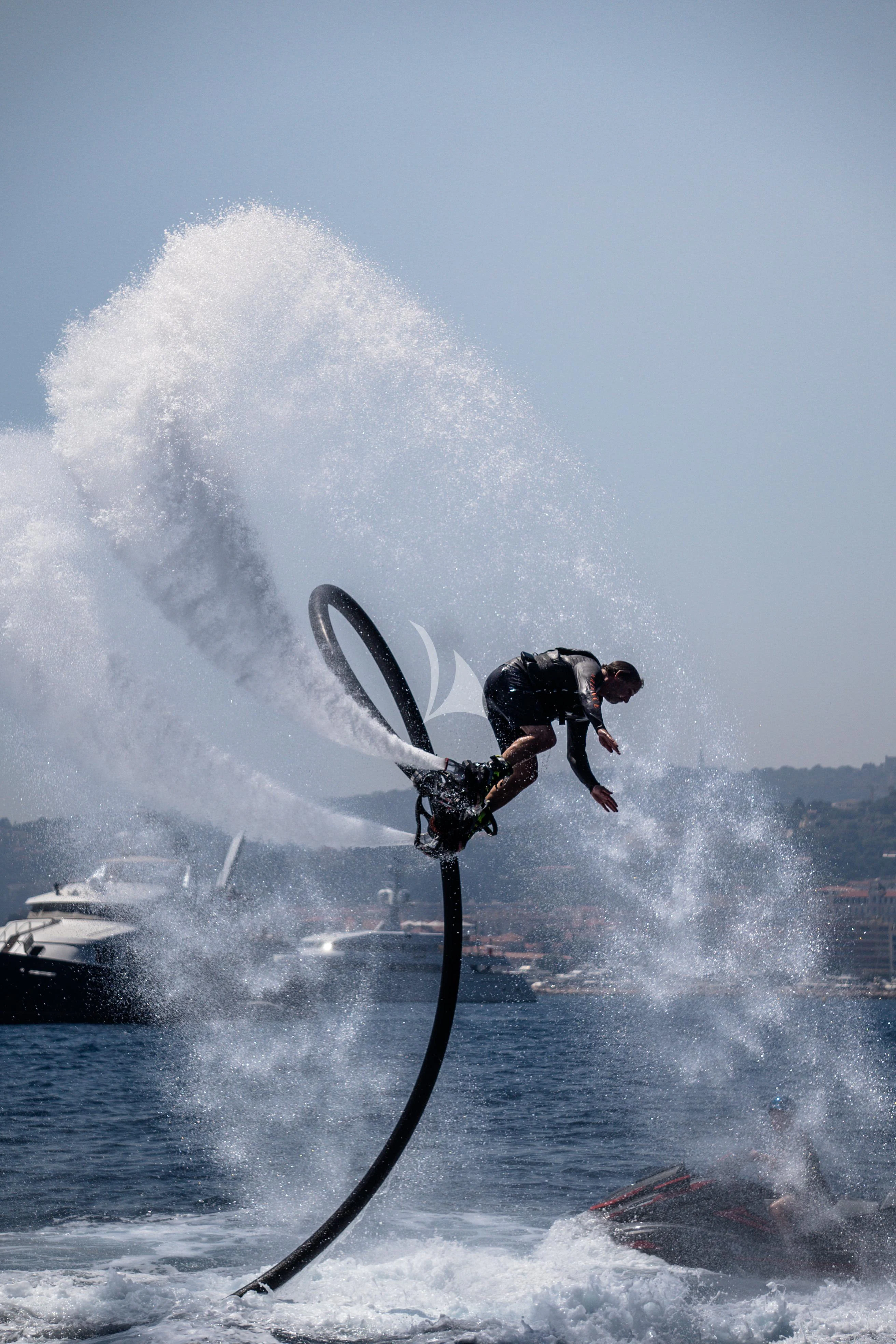 a man riding a surfboard aboard ARIENCE Yacht for Sale