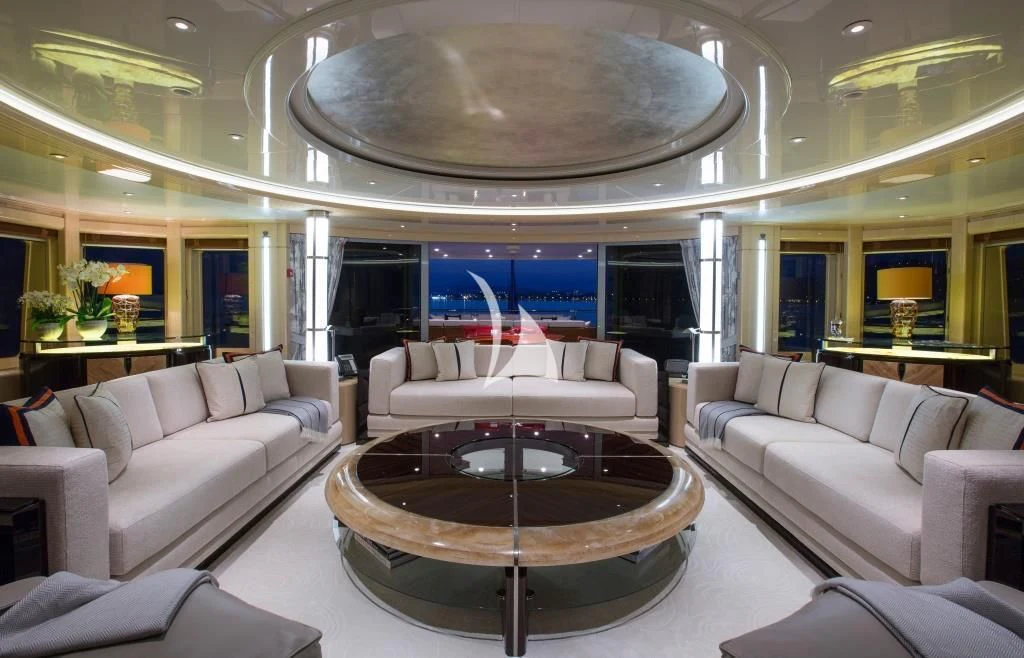 a living room with a large round table and a large chandelier aboard ARIENCE Yacht for Sale