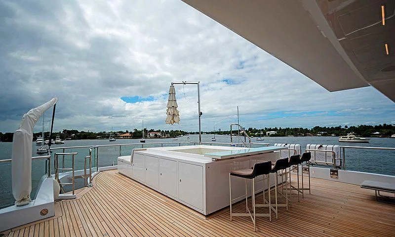 a deck with a table and chairs on it aboard QUEEN D Yacht for Sale