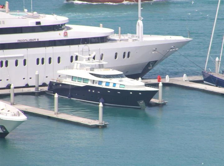 a large white boat docked at a pier aboard GHANIM Yacht for Sale