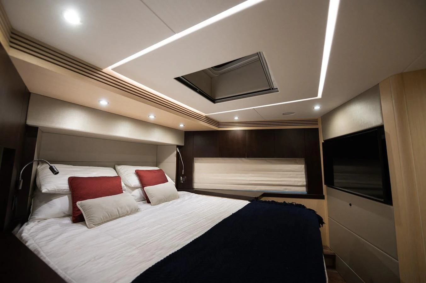 a bed with a white bed and red pillows aboard SUNSEEKER 75 YACHT Yacht for Sale