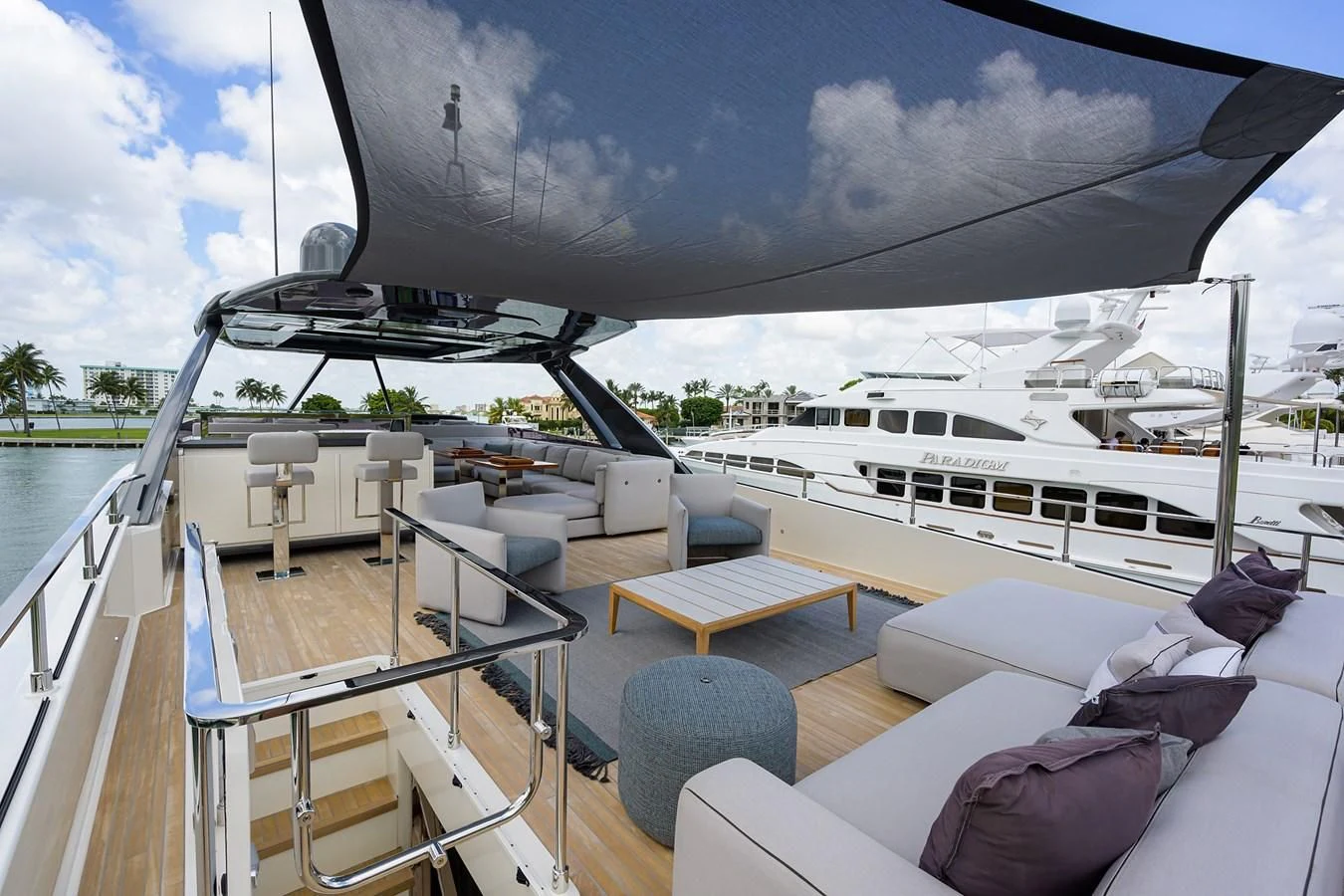 a deck with a large boat and a large deck with chairs and a large white building with trees aboard DATE NIGHT Yacht for Sale