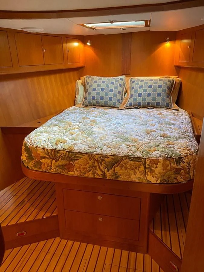 a bed with a blue comforter aboard EL CACIQUE Yacht for Sale
