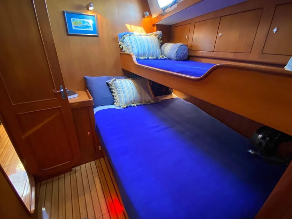 a room with beds and a television aboard EL CACIQUE Yacht for Sale