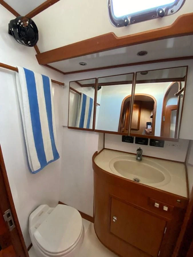 a bathroom with a toilet and a sink aboard EL CACIQUE Yacht for Sale