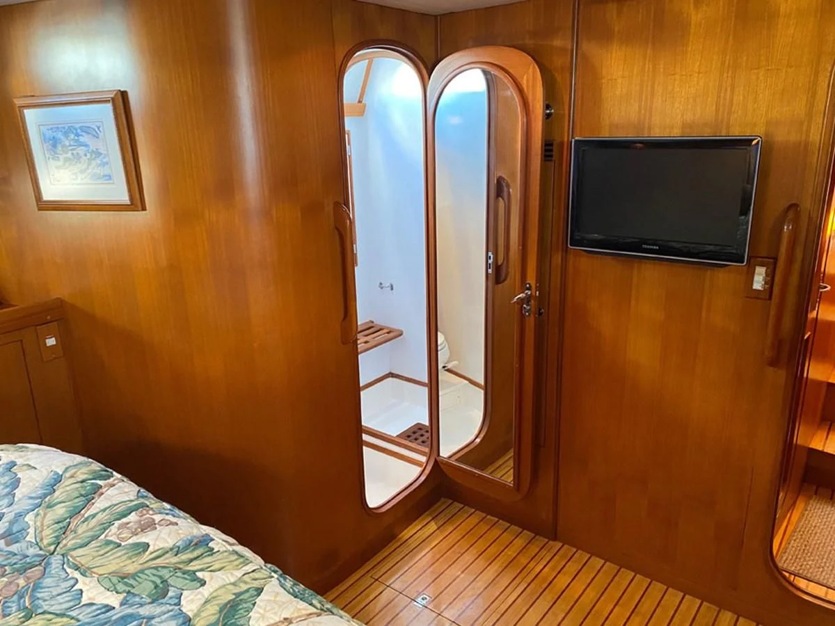 a bedroom with a bed and a television aboard EL CACIQUE Yacht for Sale