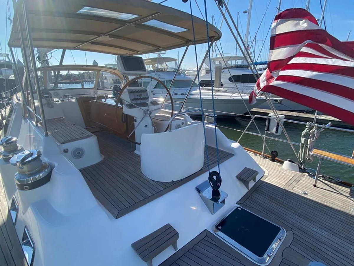 a large ship with a flag on the deck aboard EL CACIQUE Yacht for Sale