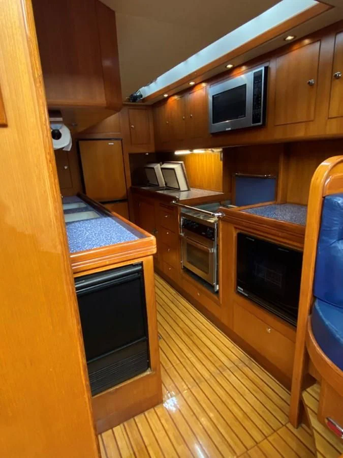 a kitchen with wooden cabinets aboard EL CACIQUE Yacht for Sale
