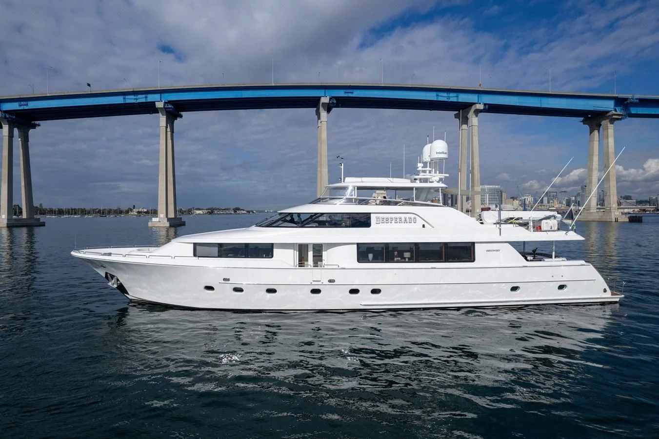 a white yacht under a bridge aboard DESPERADO Yacht for Sale