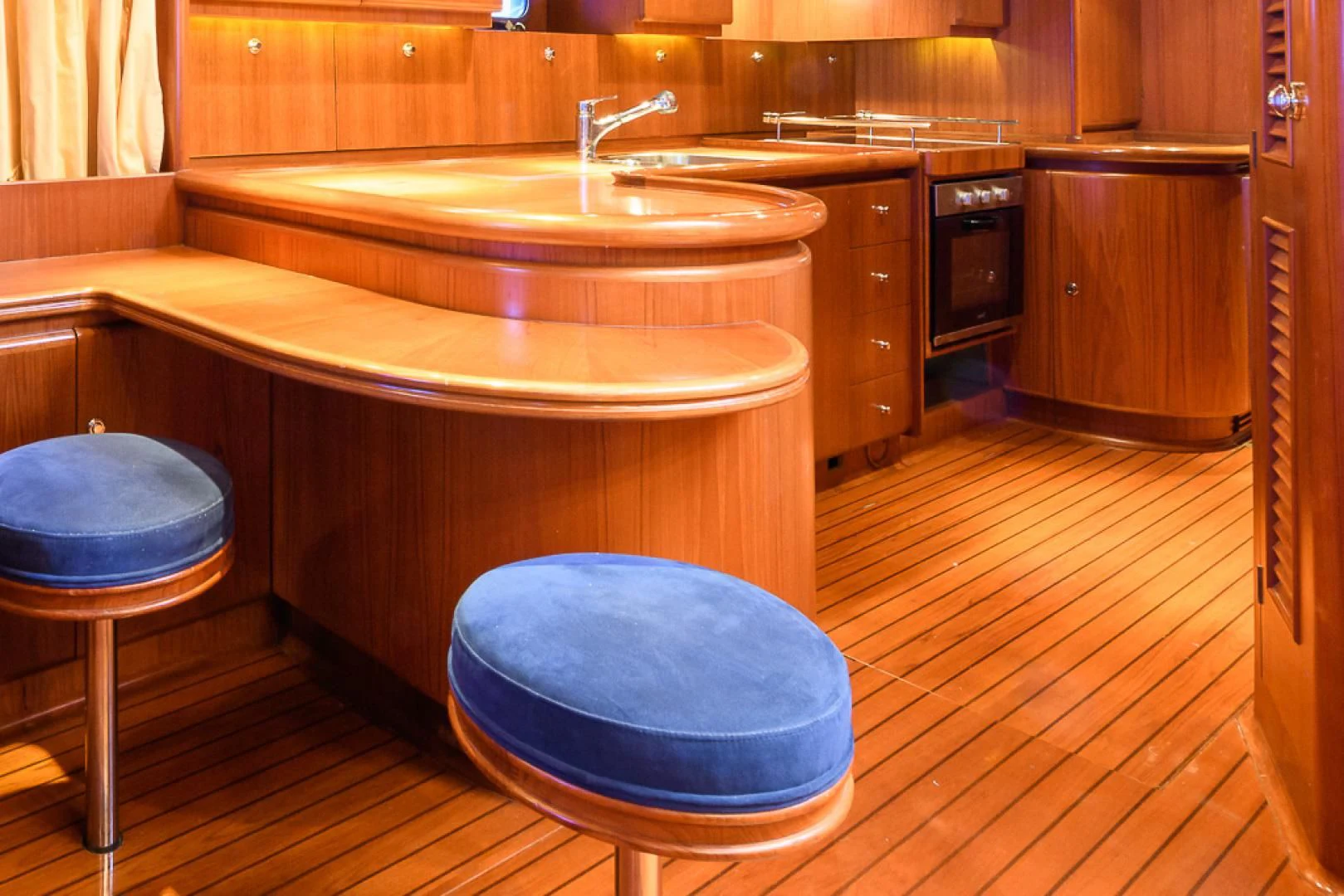 a kitchen with a blue stool aboard CRYSTAL Yacht for Sale