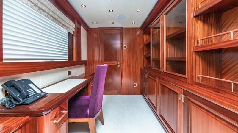 a chair and a desk in a room with wood cabinets aboard BLUE TIME Yacht for Sale