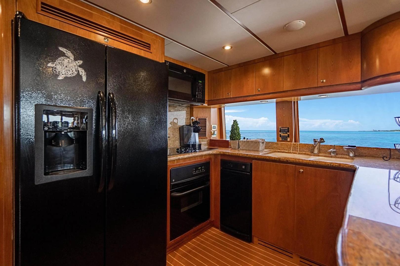a kitchen with black appliances aboard ROXY MARIA Yacht for Sale