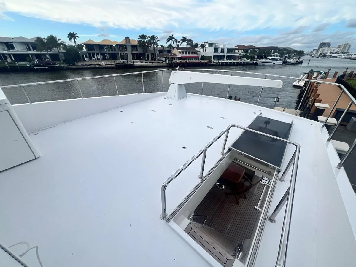 a deck with a boat and a dock with boats in the background aboard ROXY MARIA Yacht for Sale
