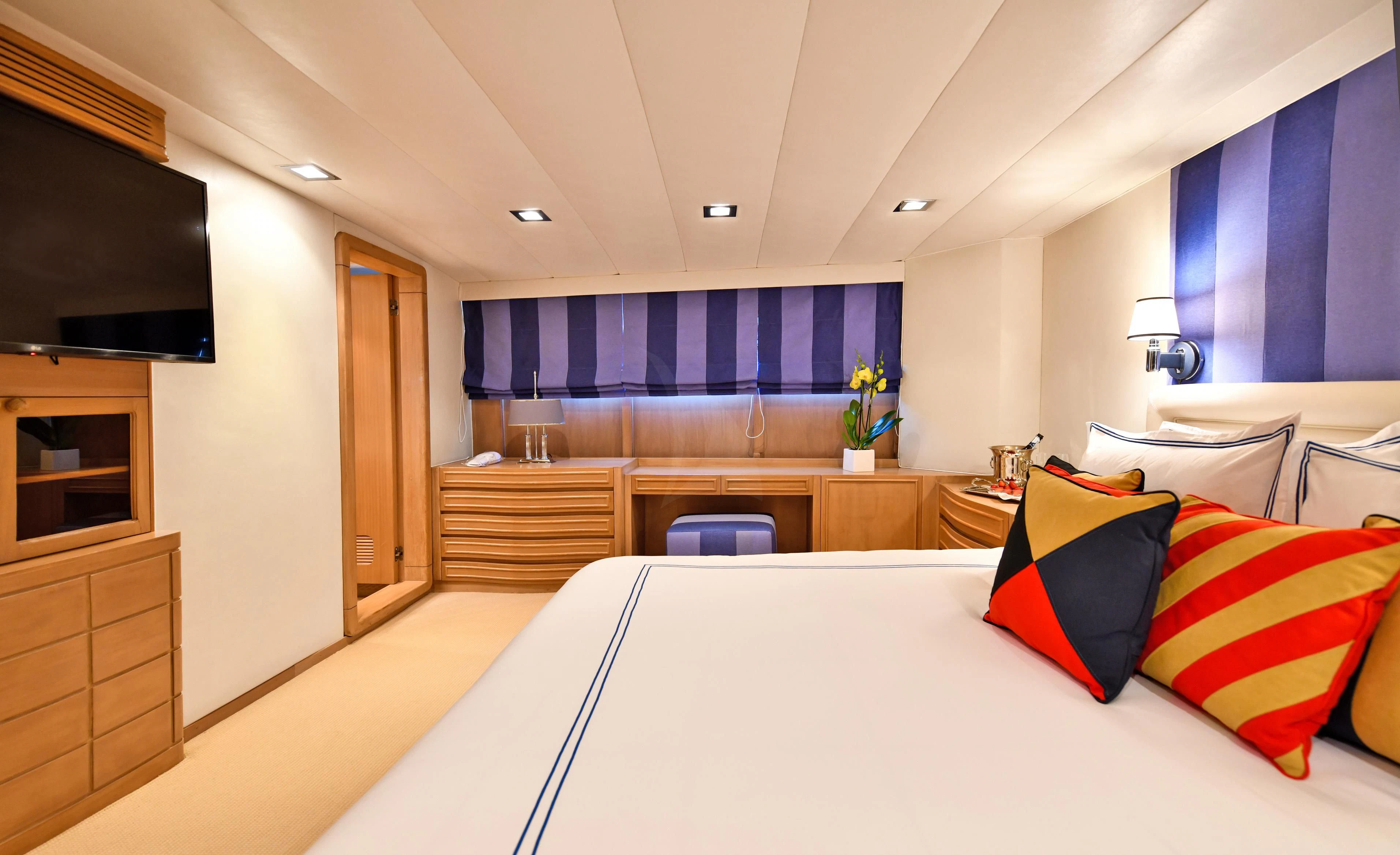 a bed with white sheets and pillows aboard SOMETHING COOL Yacht for Charter