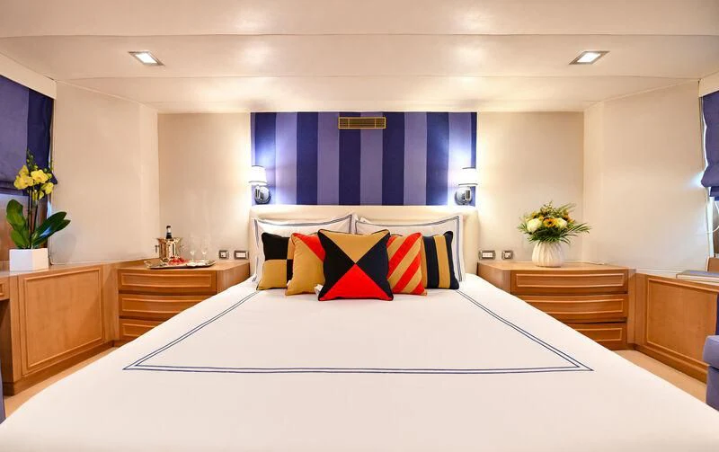 a large bed with white sheets and pillows aboard SOMETHING COOL Yacht for Charter