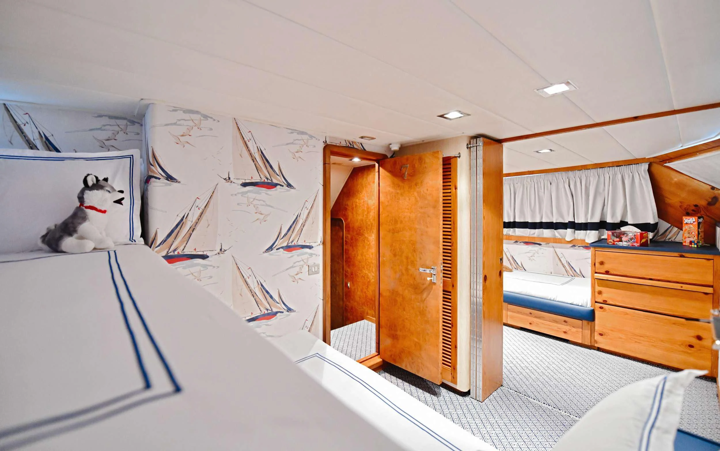 a room with a bed and a desk with a cat on it aboard SOMETHING COOL Yacht for Charter