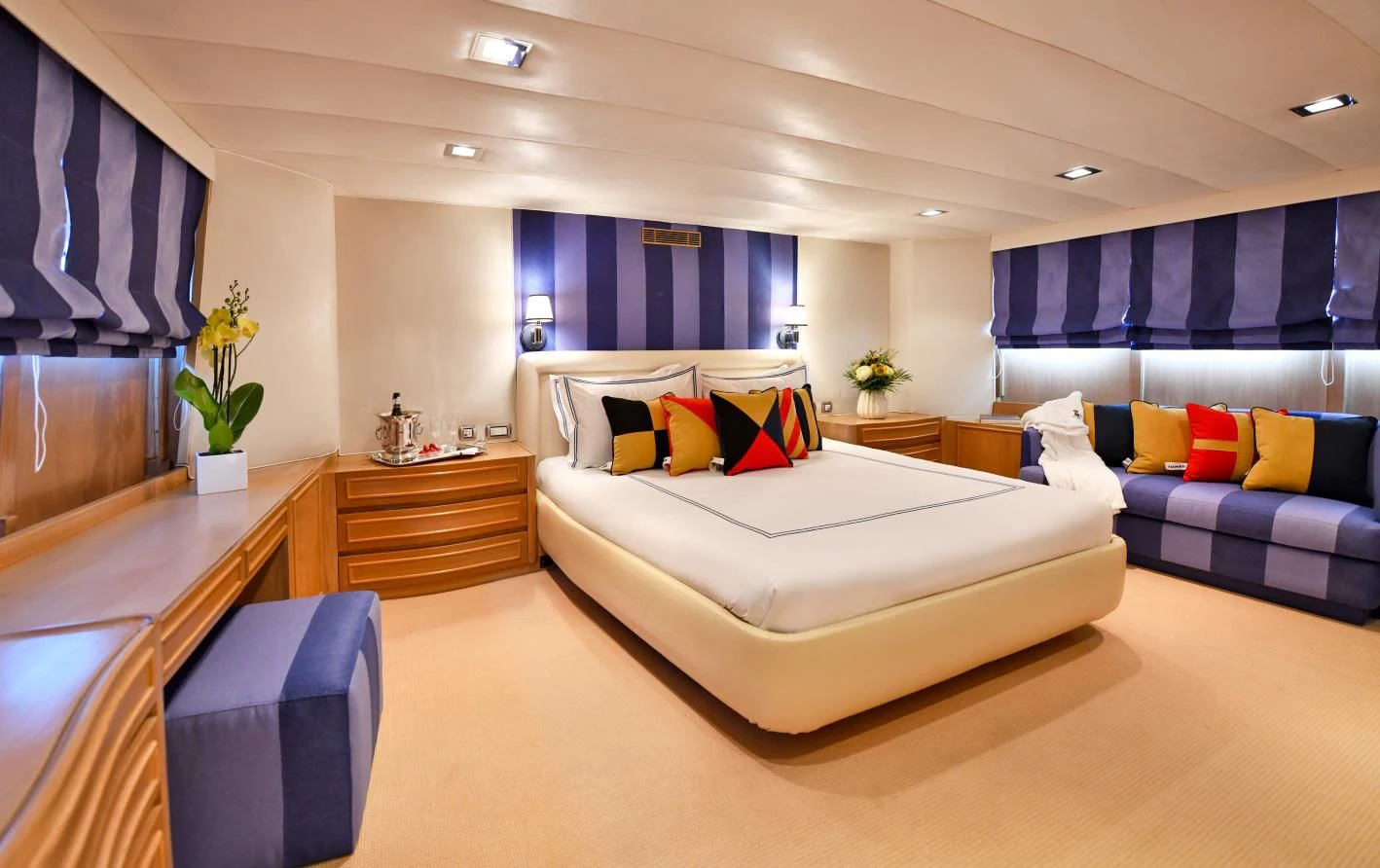 a large room with a bed and a desk aboard SOMETHING COOL Yacht for Charter