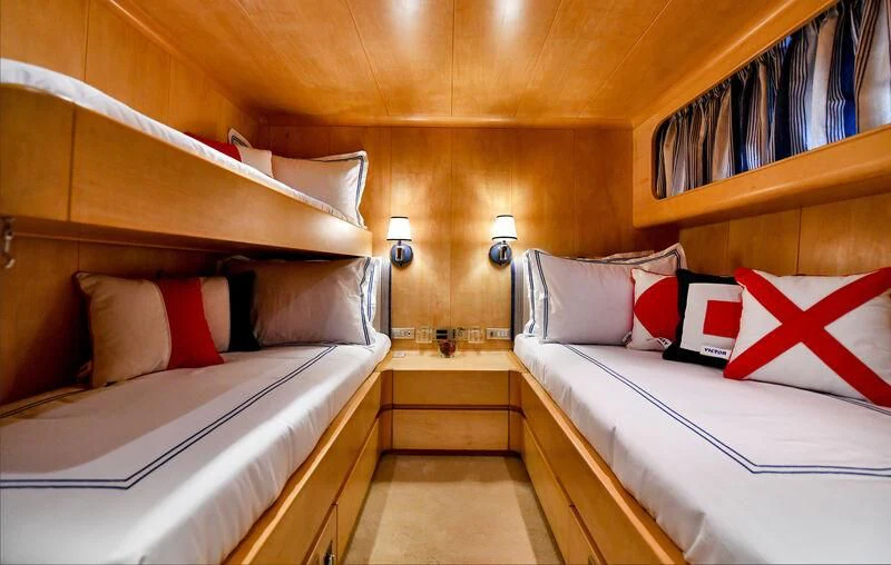 a room with beds and a wood wall aboard SOMETHING COOL Yacht for Charter