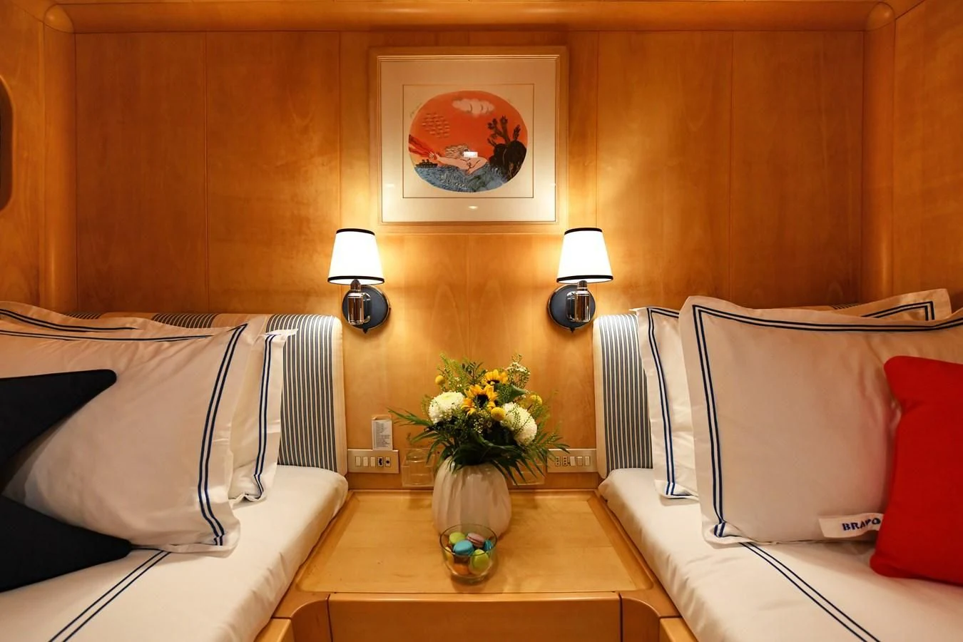 a room with a bed and a table with a vase of flowers aboard SOMETHING COOL Yacht for Charter