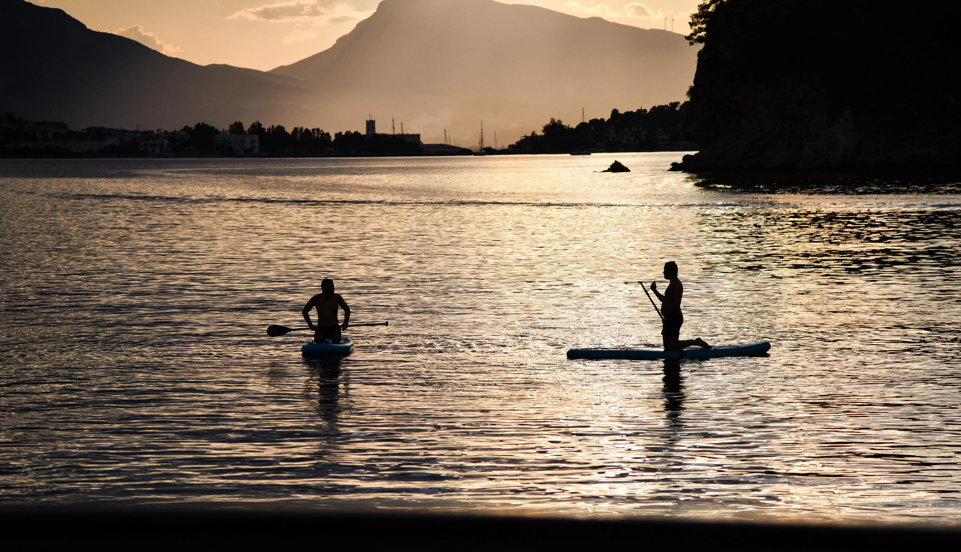 a couple of people paddle on surfboards in the water aboard SOMETHING COOL Yacht for Charter