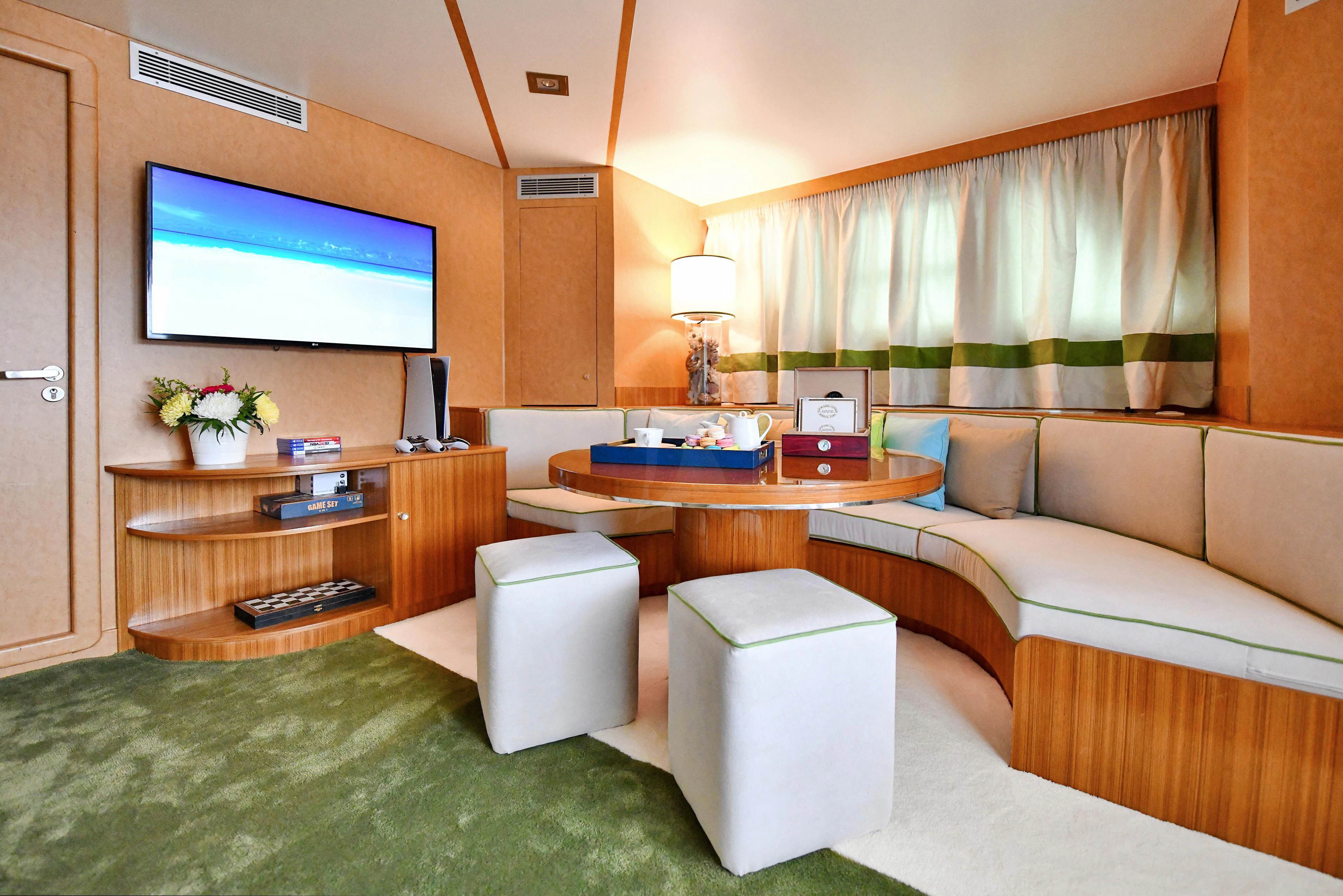 a living room with a couch and a television aboard SOMETHING COOL Yacht for Charter