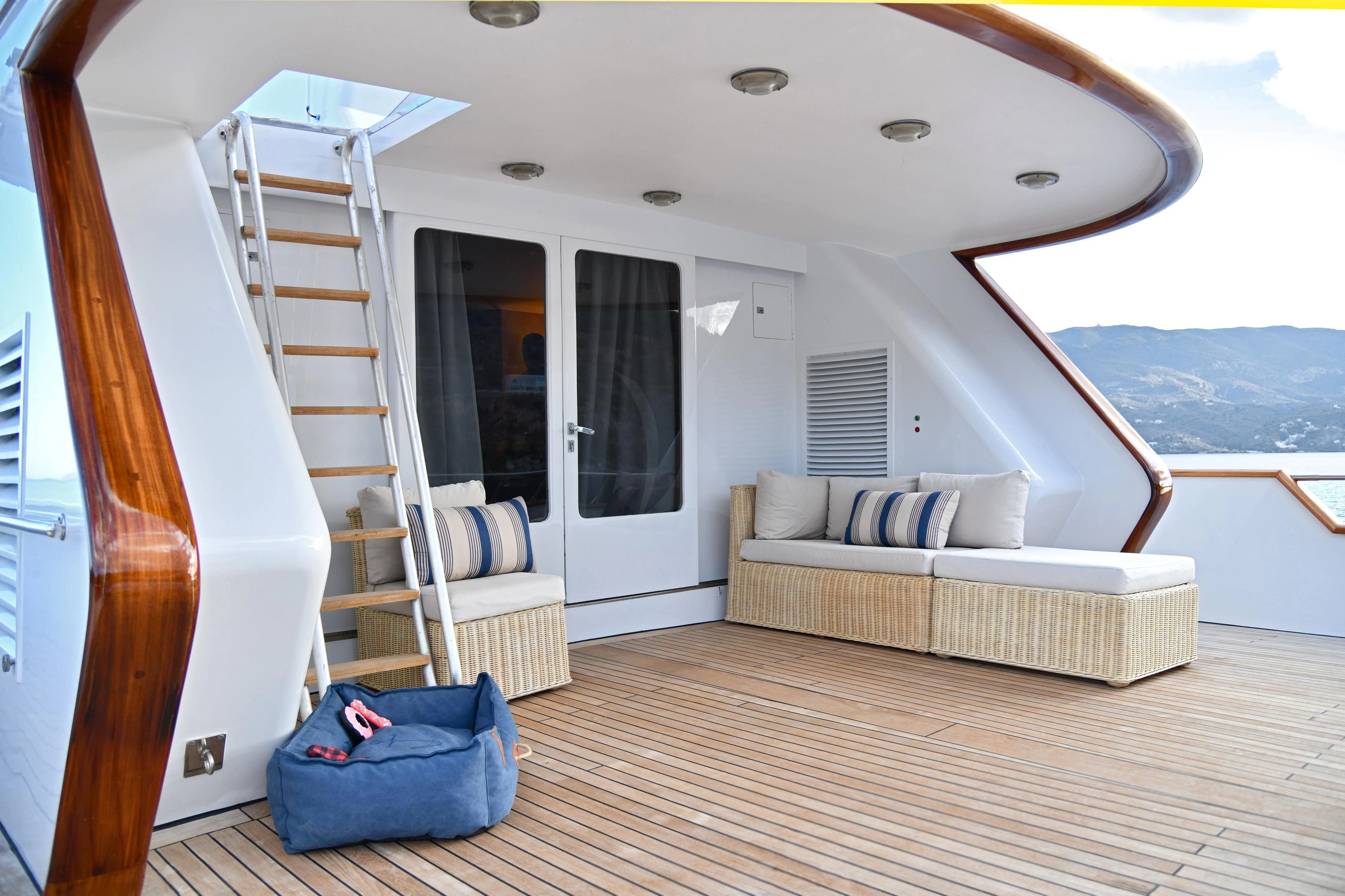 a room with a bed and a blue couch aboard SOMETHING COOL Yacht for Charter