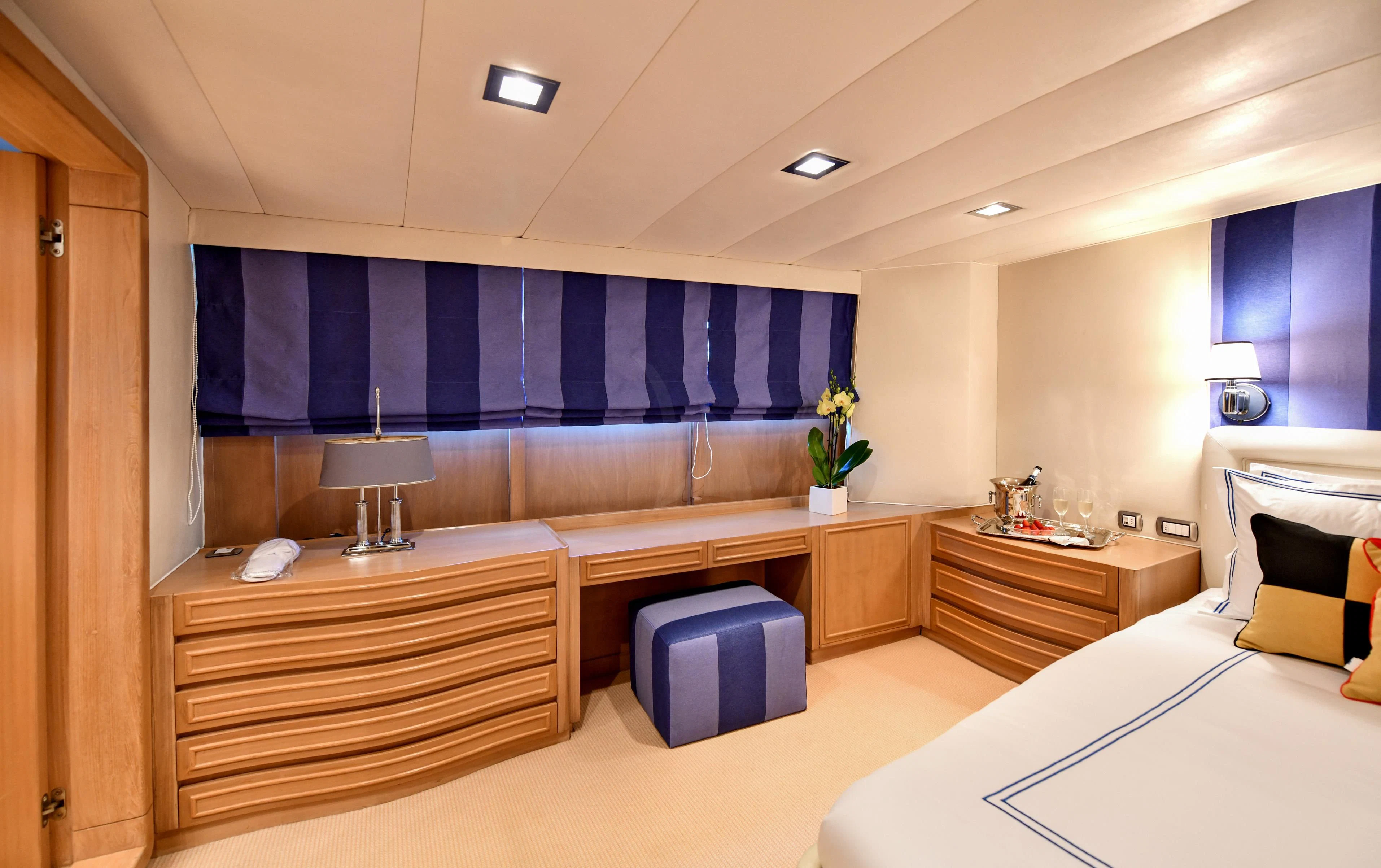 a room with a bed and desk aboard SOMETHING COOL Yacht for Charter