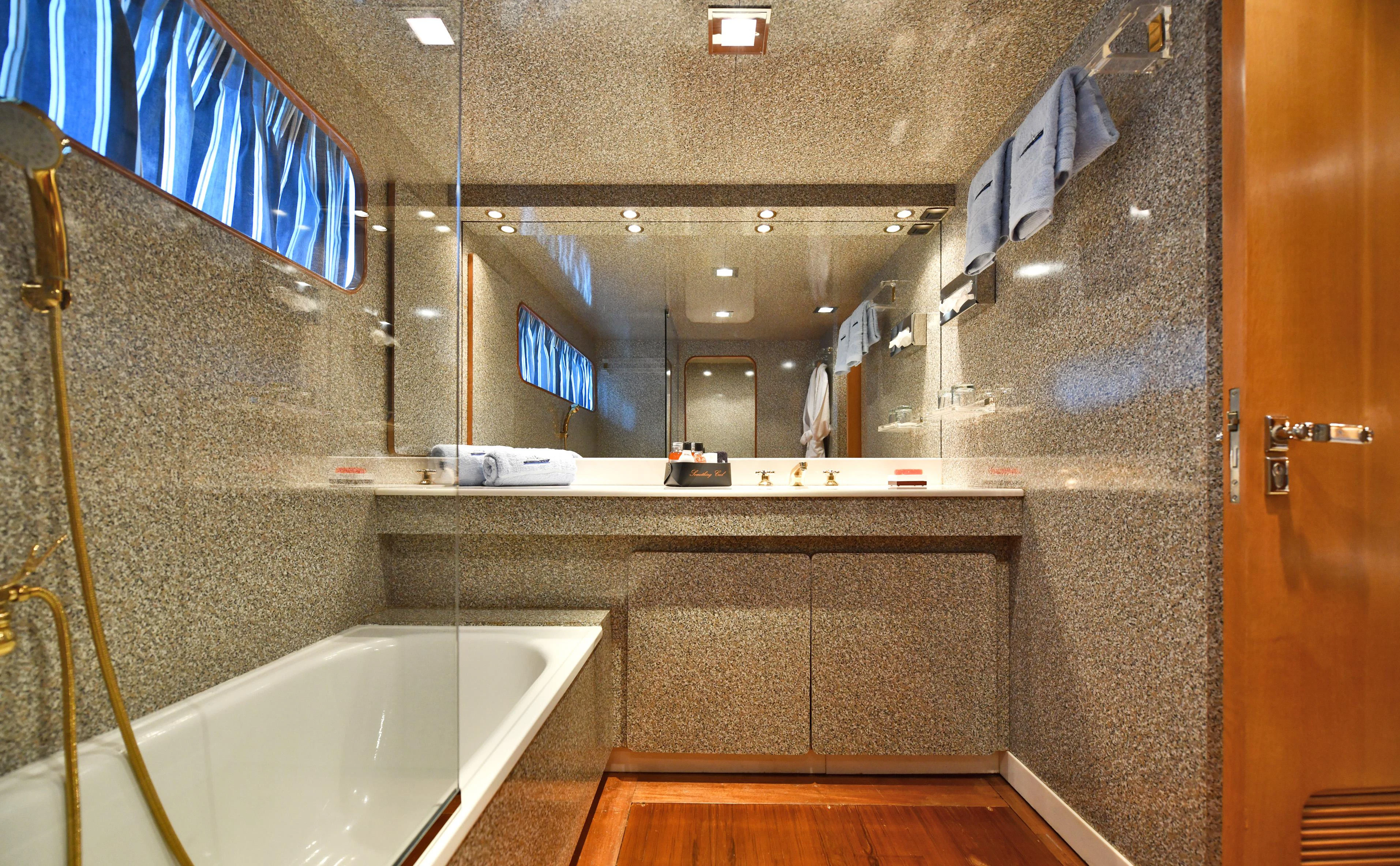 a bathroom with a bathtub and a sink aboard SOMETHING COOL Yacht for Charter