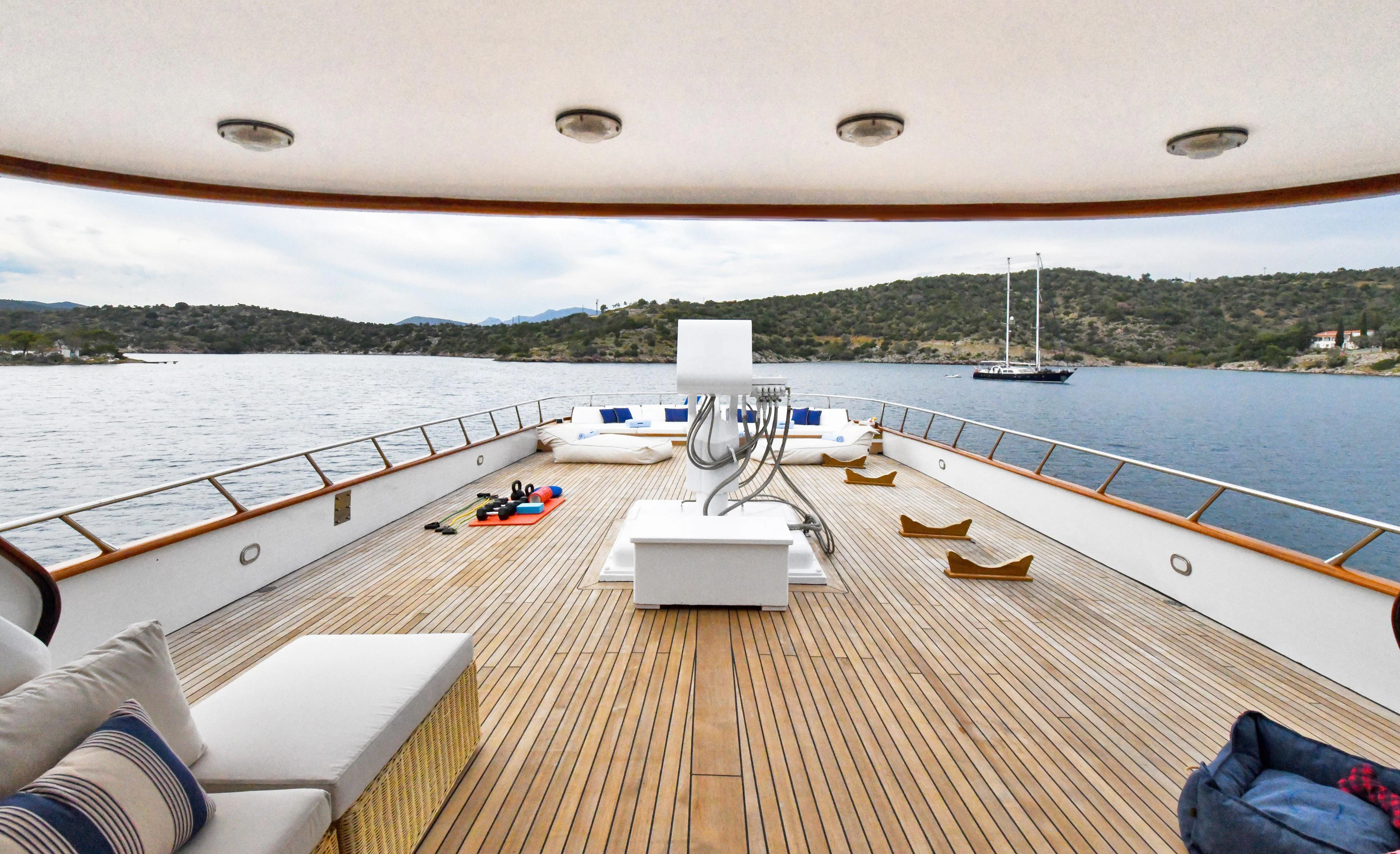 a deck with a view of a body of water and boats on it aboard SOMETHING COOL Yacht for Charter
