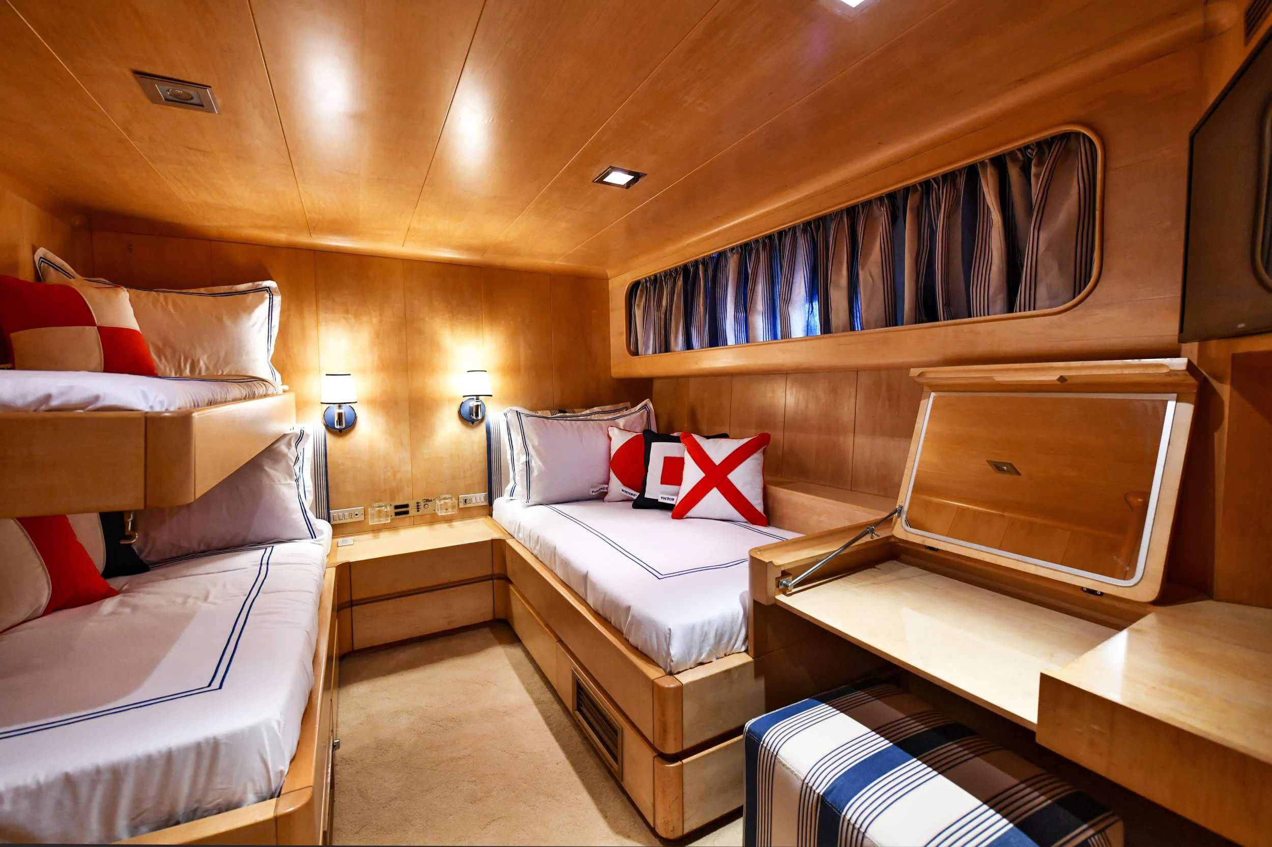 a room with a bed and a dresser aboard SOMETHING COOL Yacht for Charter