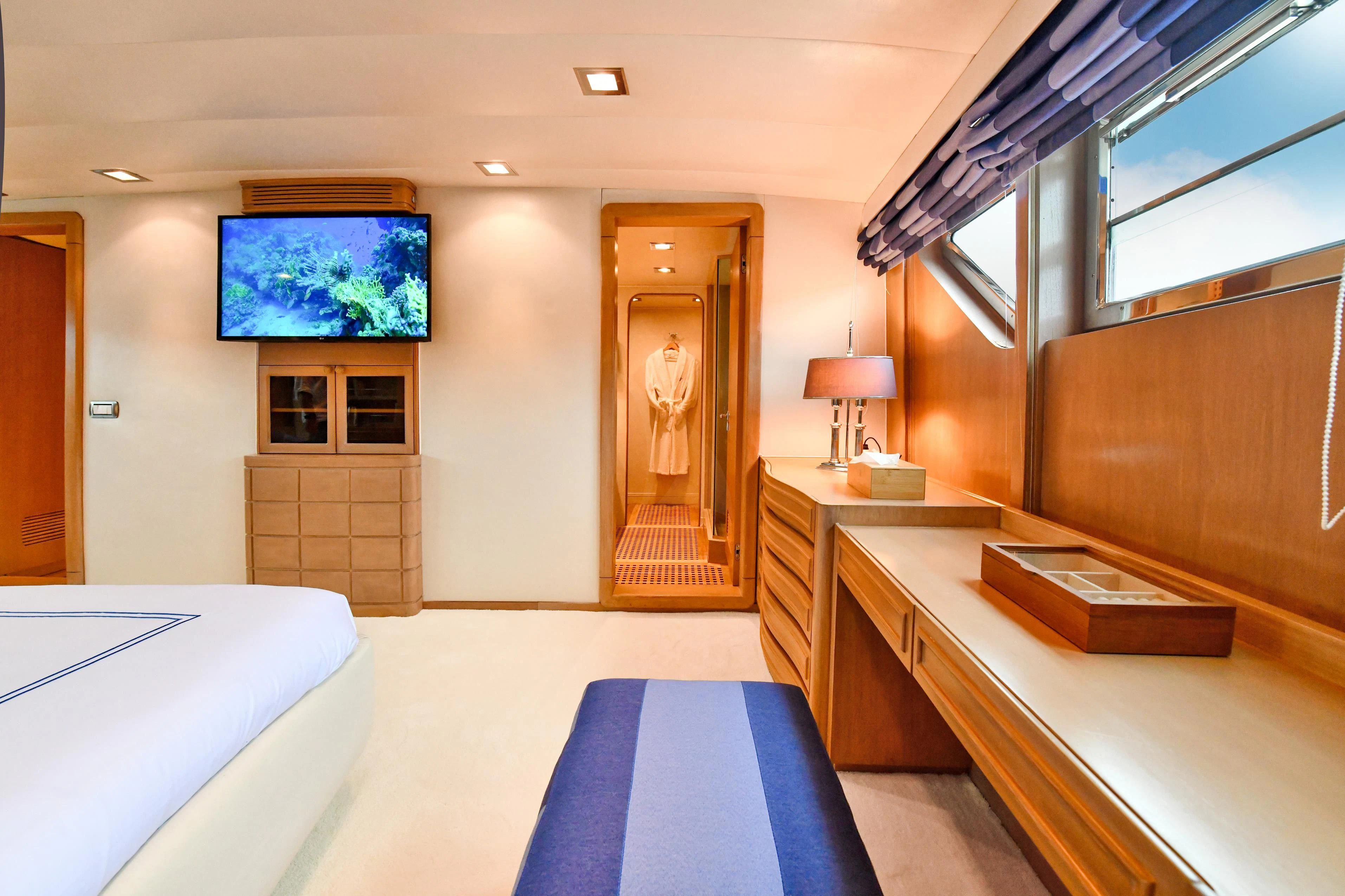 a room with a bed and a desk aboard SOMETHING COOL Yacht for Charter
