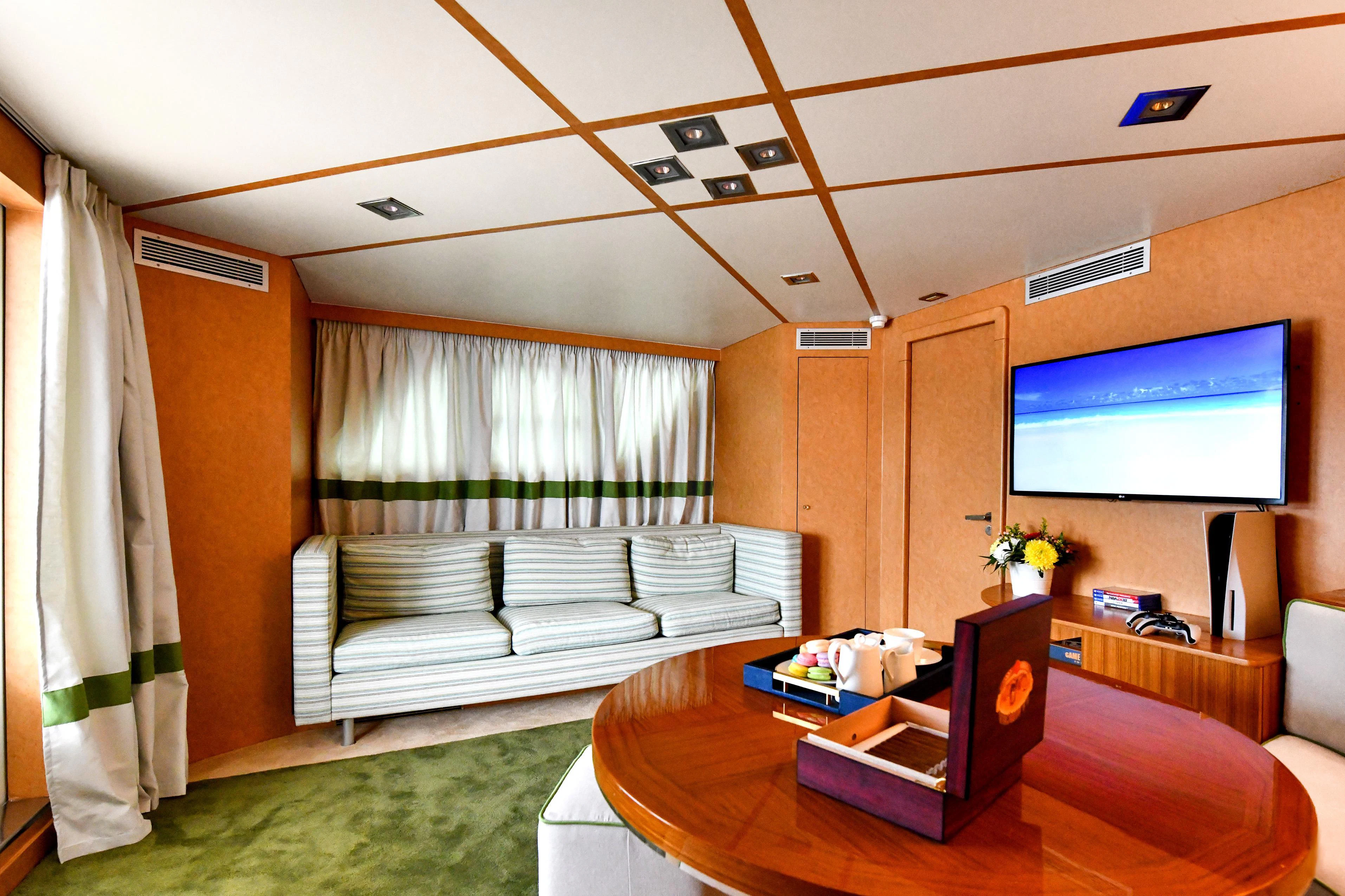 a living room with a large screen aboard SOMETHING COOL Yacht for Charter