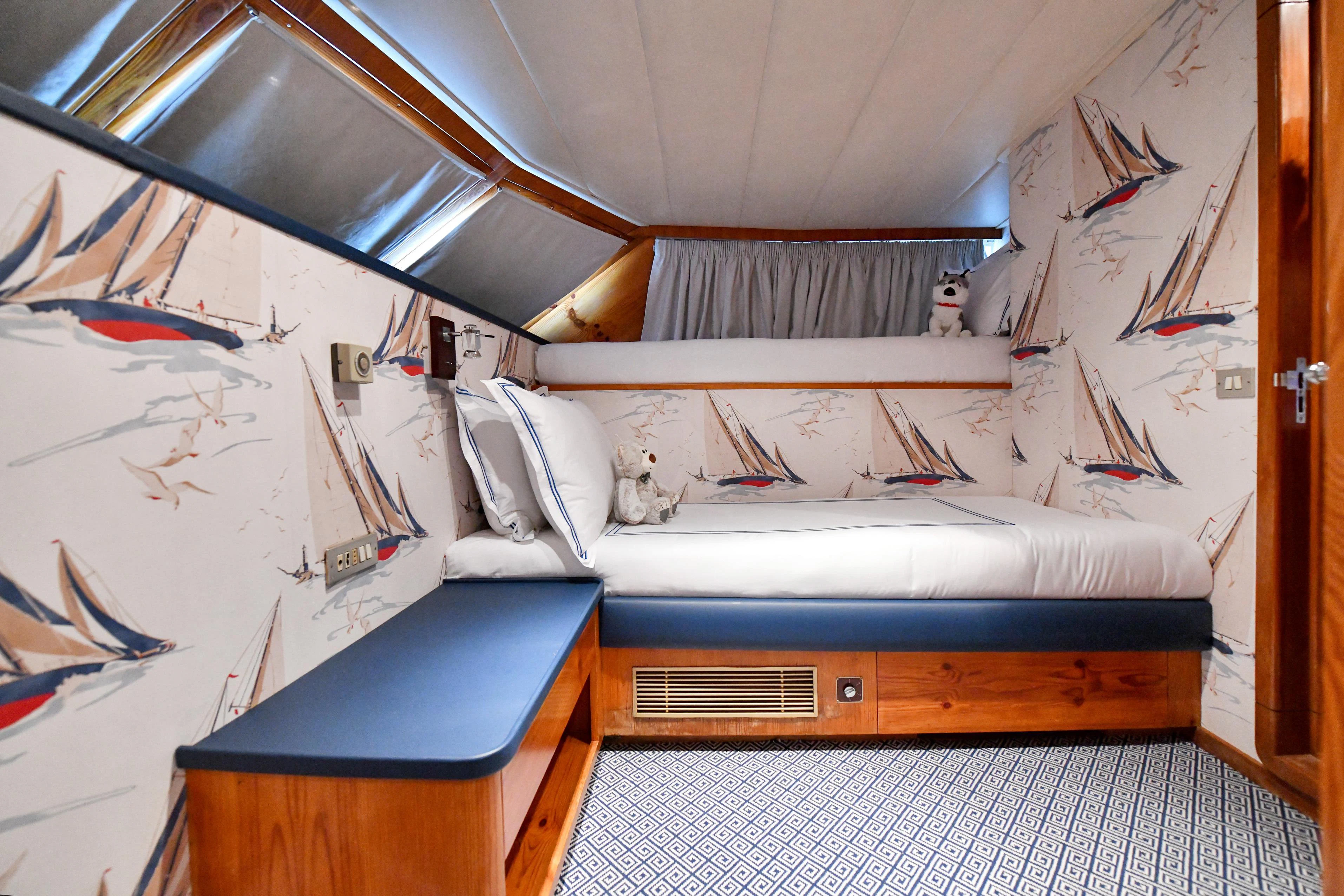 a room with a bed and a desk aboard SOMETHING COOL Yacht for Charter