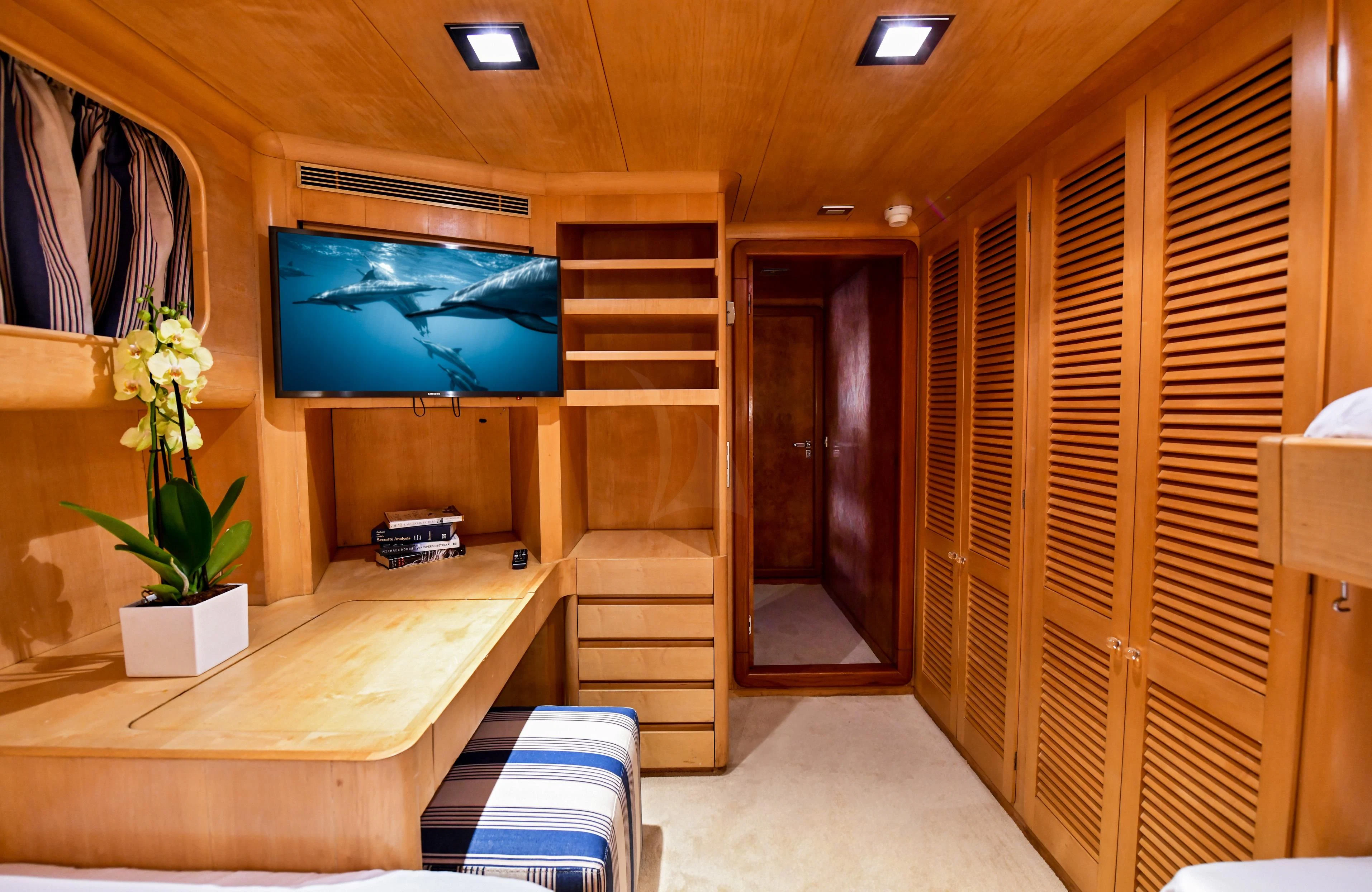 a room with a tv and a table aboard SOMETHING COOL Yacht for Charter