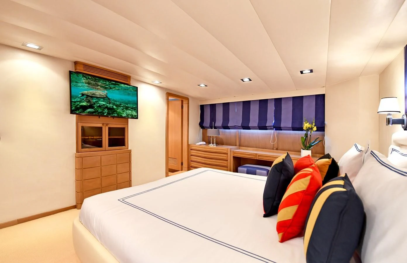 a hotel room with a bed and a tv aboard SOMETHING COOL Yacht for Charter