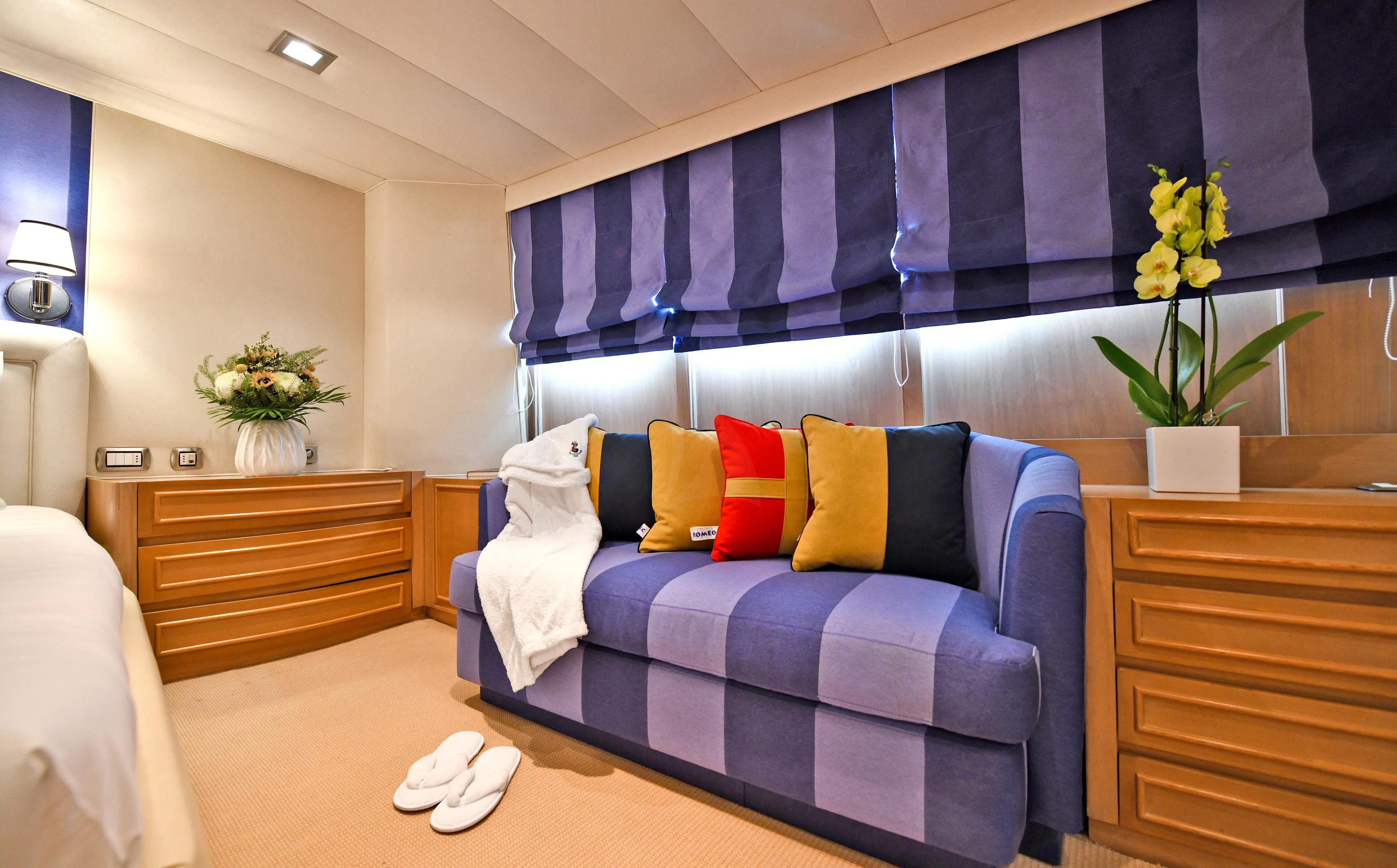 a bed with blue and red pillows aboard SOMETHING COOL Yacht for Charter