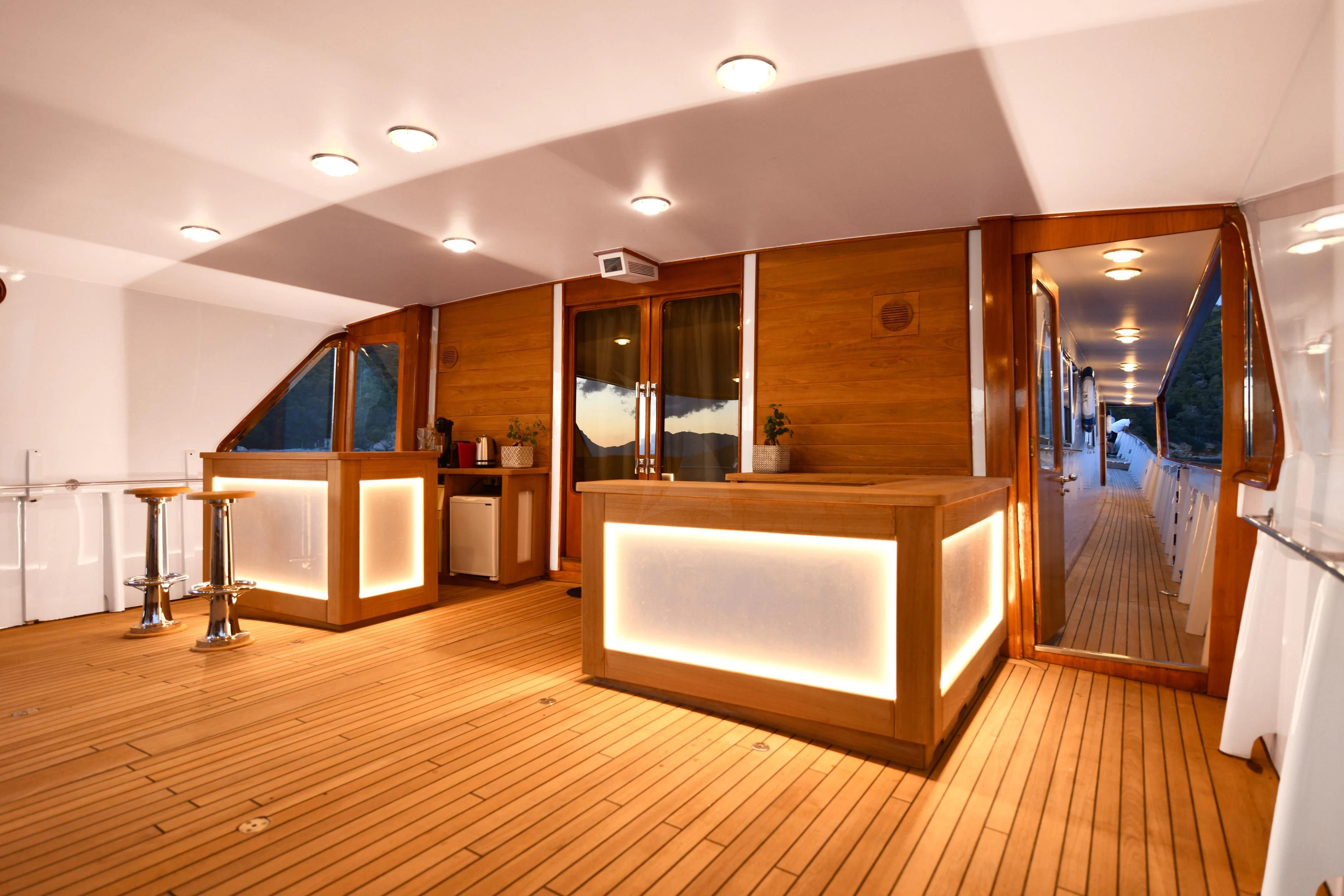 a large room with a wood floor and a large mirror aboard SOMETHING COOL Yacht for Charter