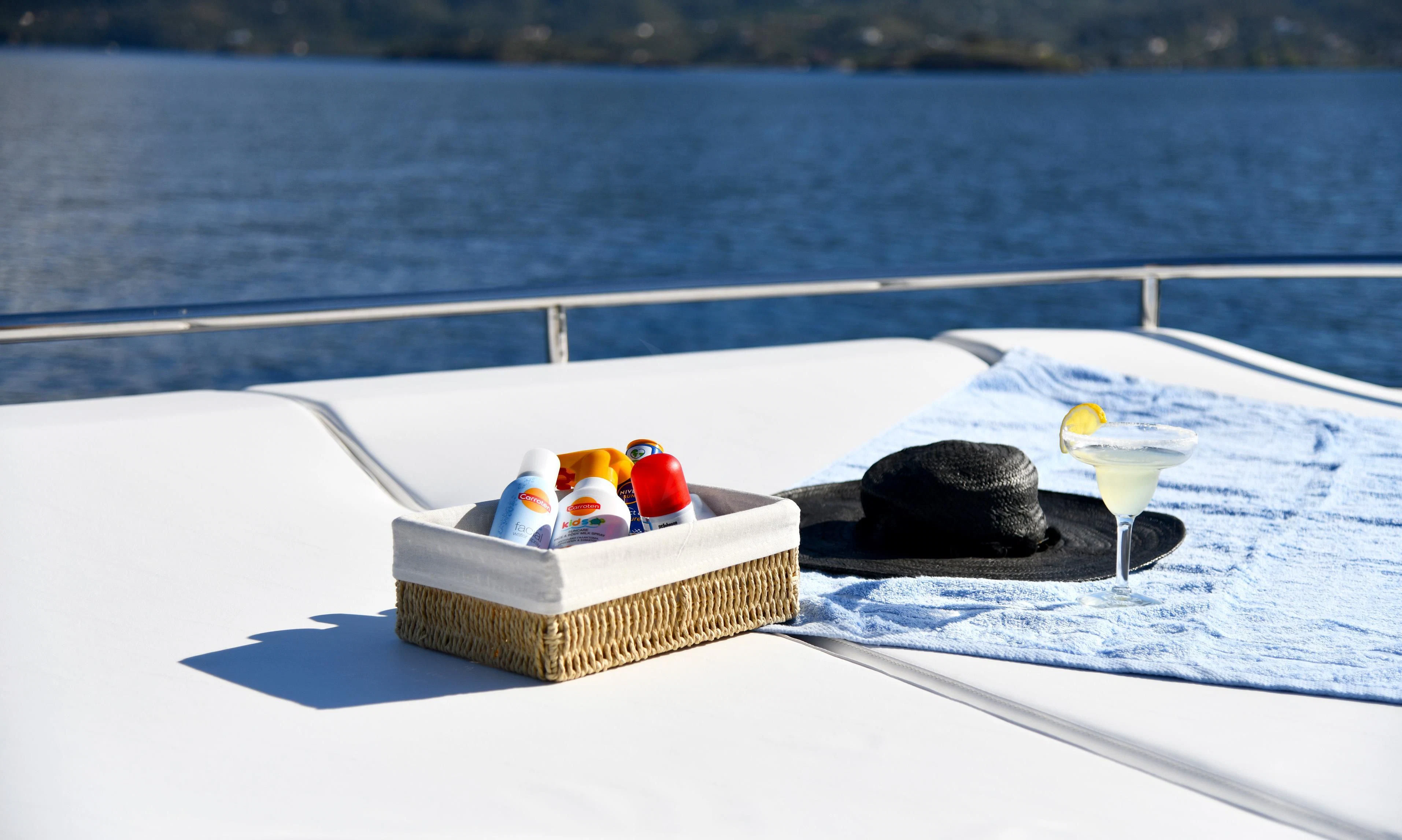 a tray with food and drinks on it by a body of water aboard SOMETHING COOL Yacht for Charter