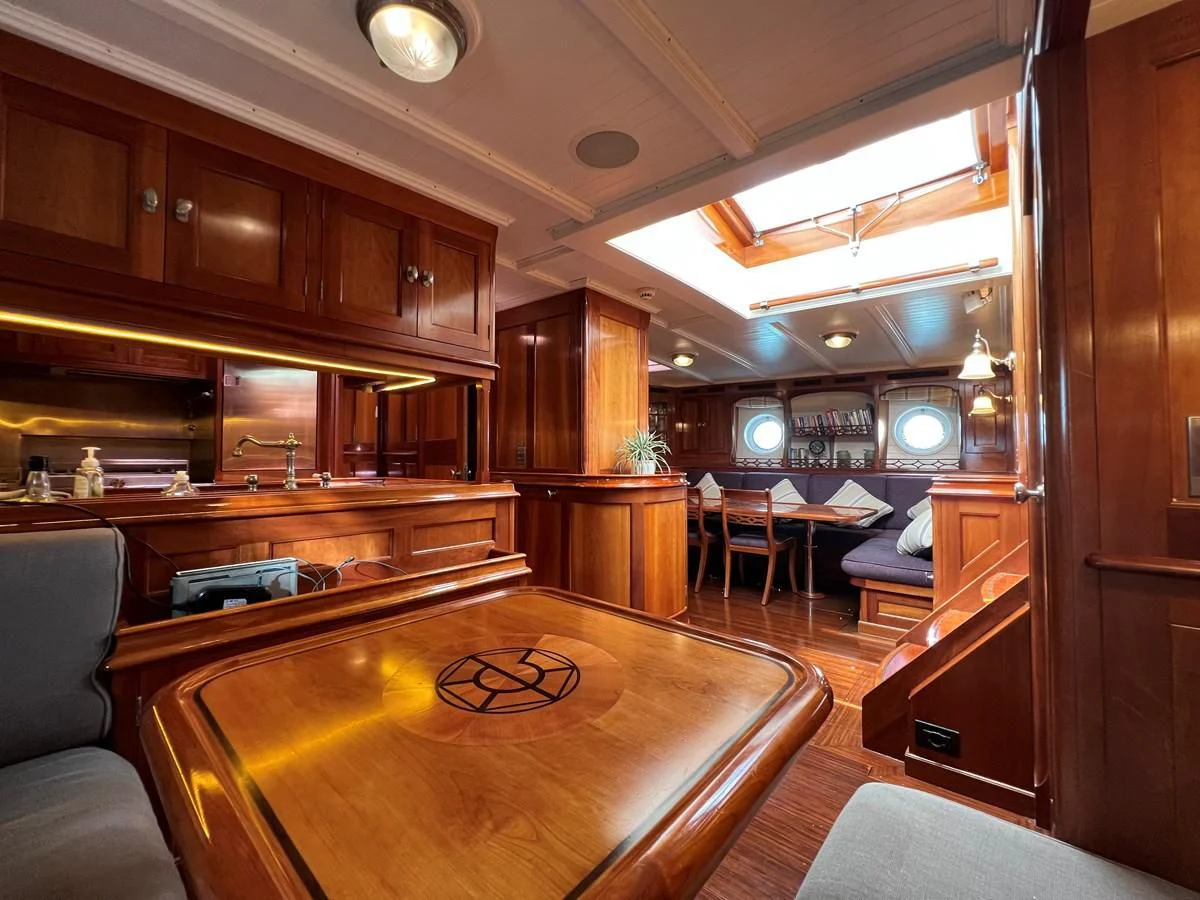 a room with a bar and a table aboard URIEL Yacht for Sale
