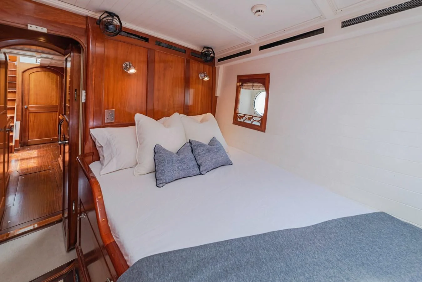 a bed with a blue sheet aboard URIEL Yacht for Sale