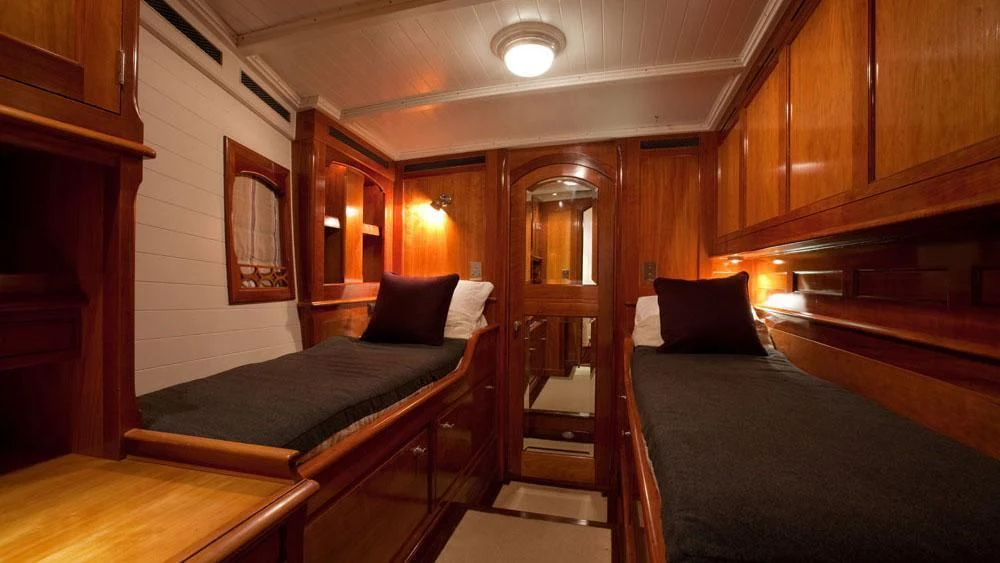 a room with a bed and a mirror aboard URIEL Yacht for Sale