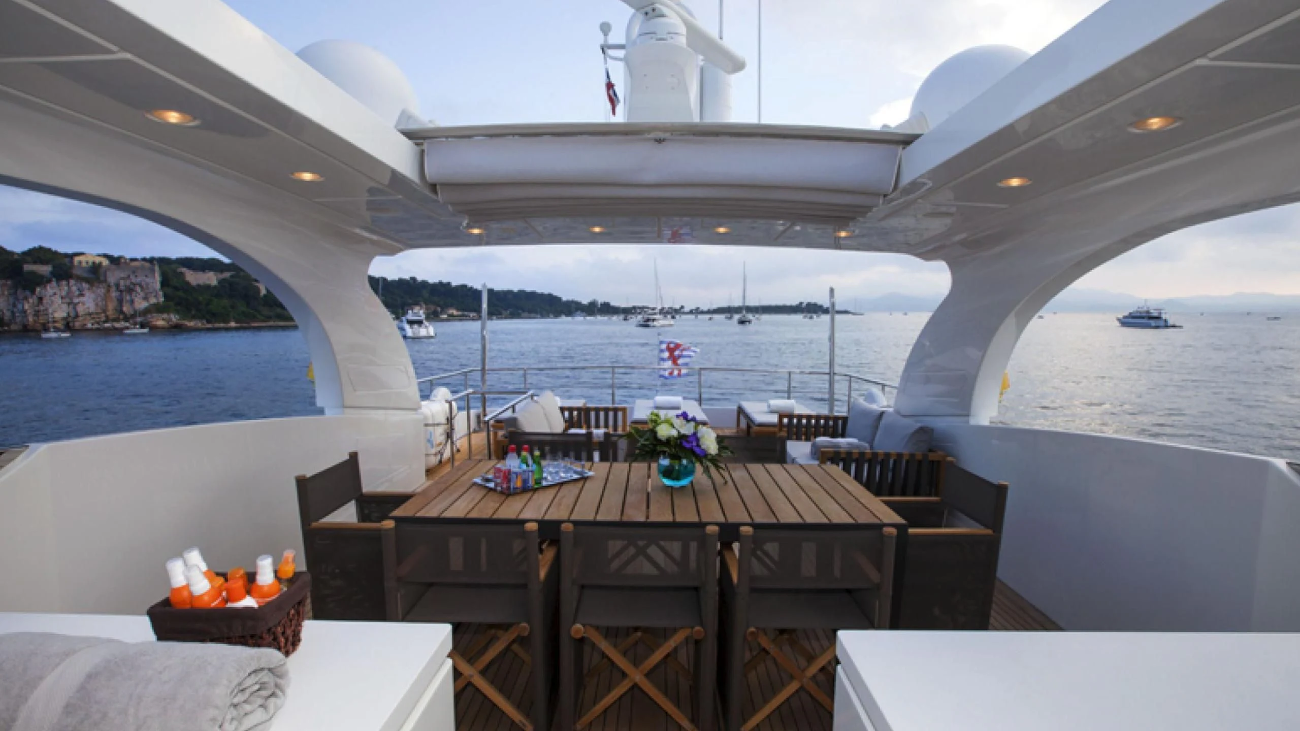 a table with candles on it by a large body of water aboard PERTULA Yacht for Sale