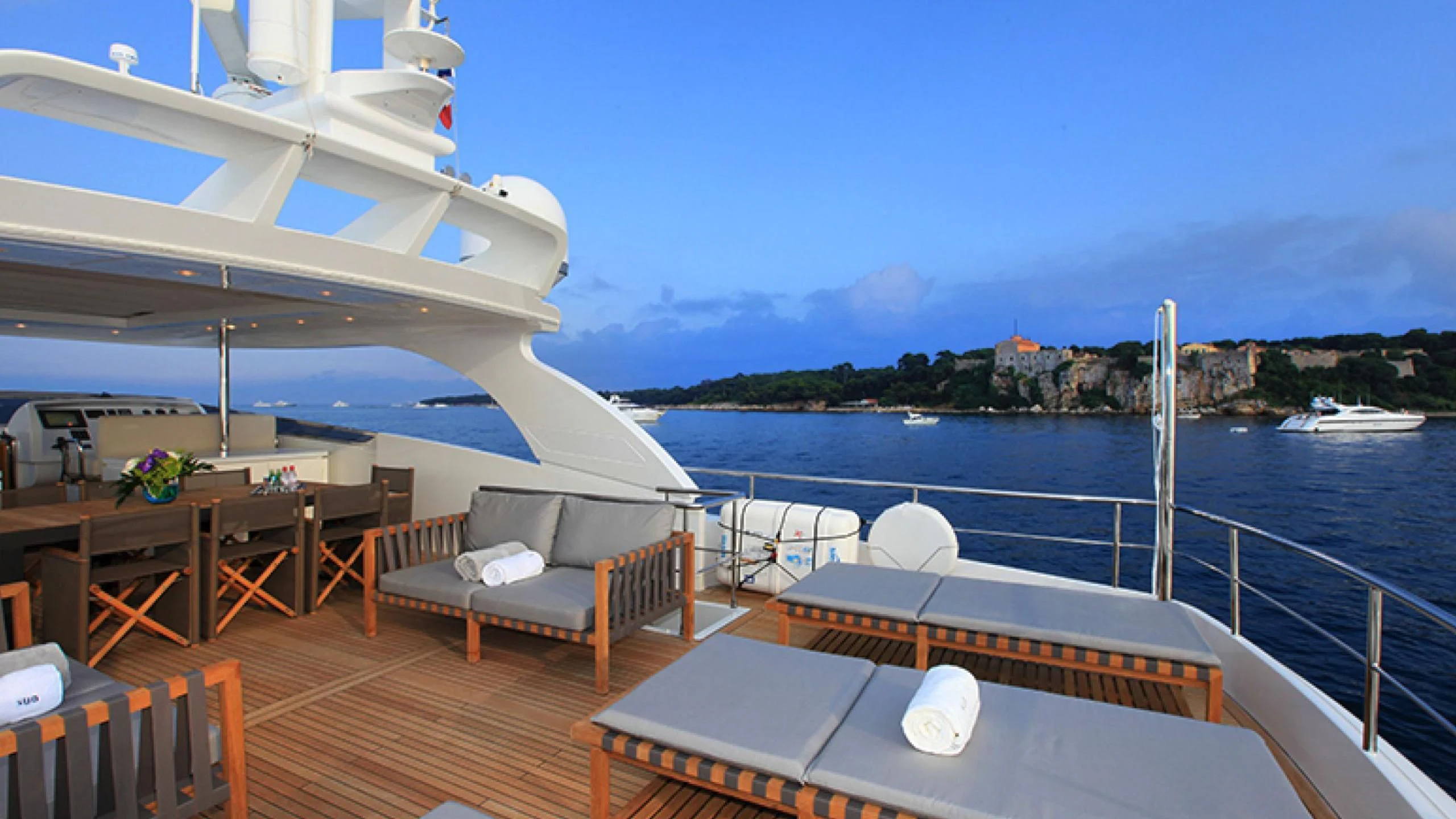 a deck with a view of the water and a boat aboard PERTULA Yacht for Sale