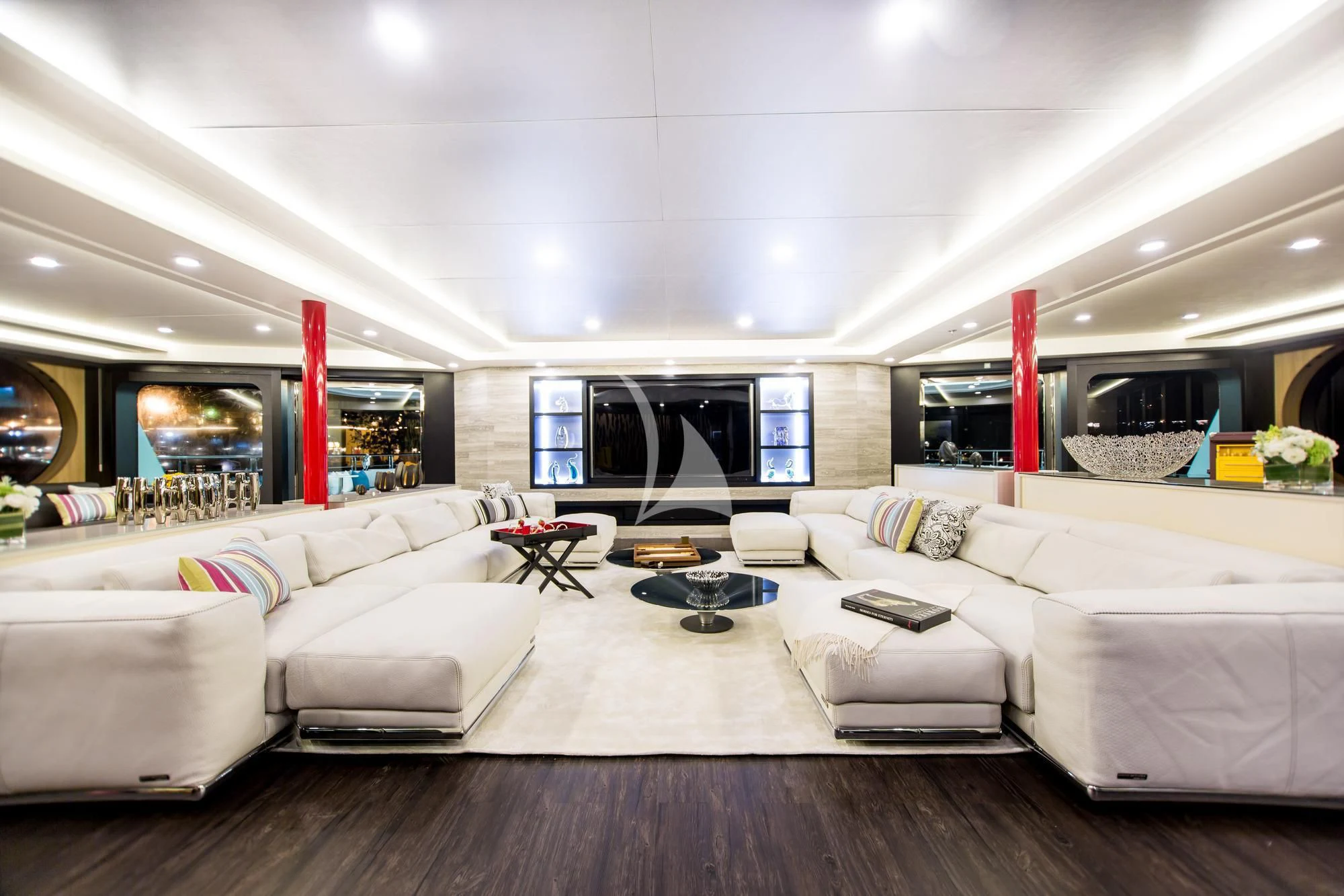 a living room with a large white couch and a large fireplace aboard SALUZI Yacht for Charter