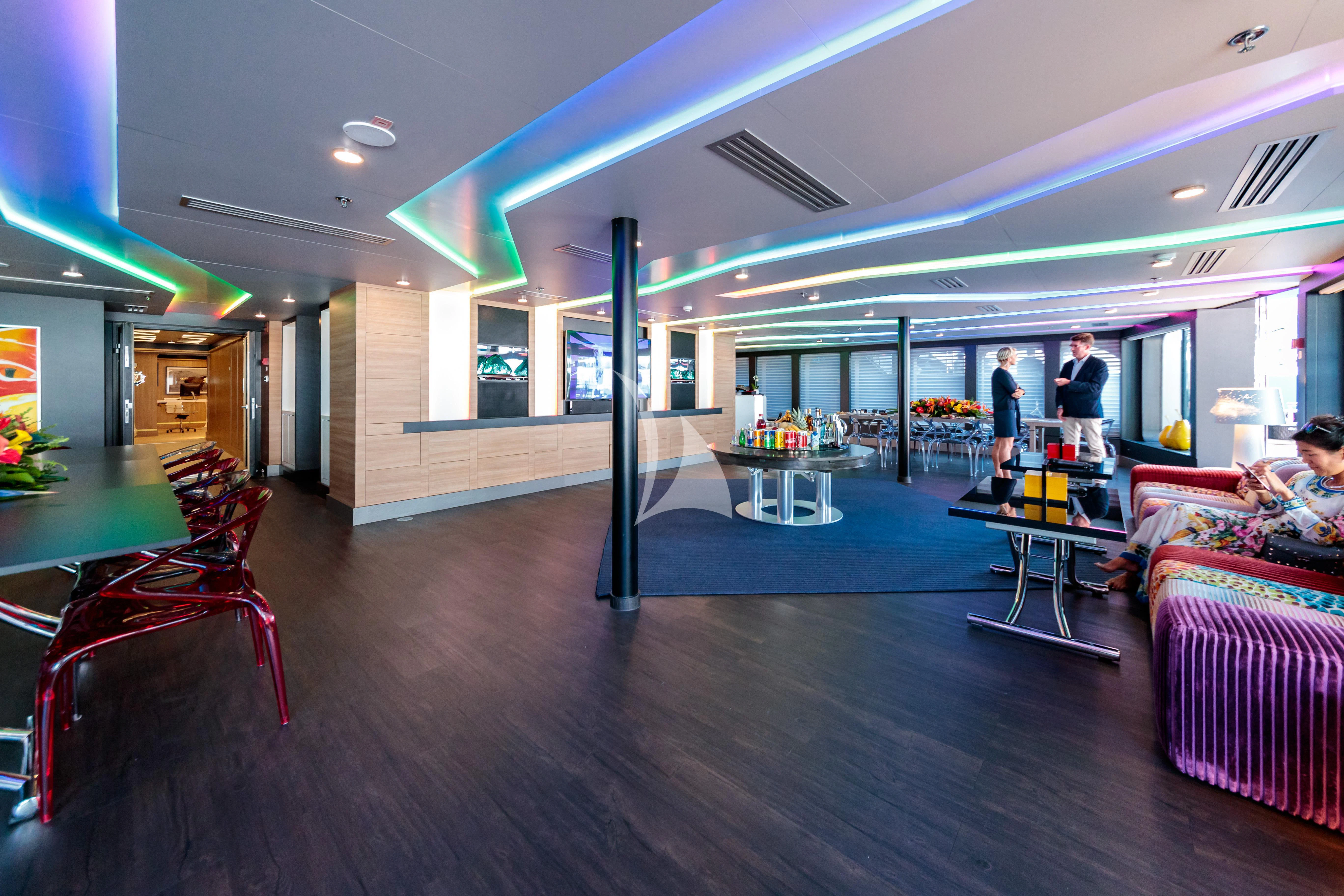 a room with a couple of people and a table aboard SALUZI Yacht for Charter