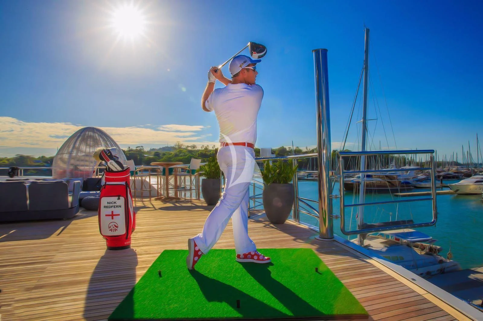 a person standing on a platform holding a flag and a can aboard SALUZI Yacht for Charter