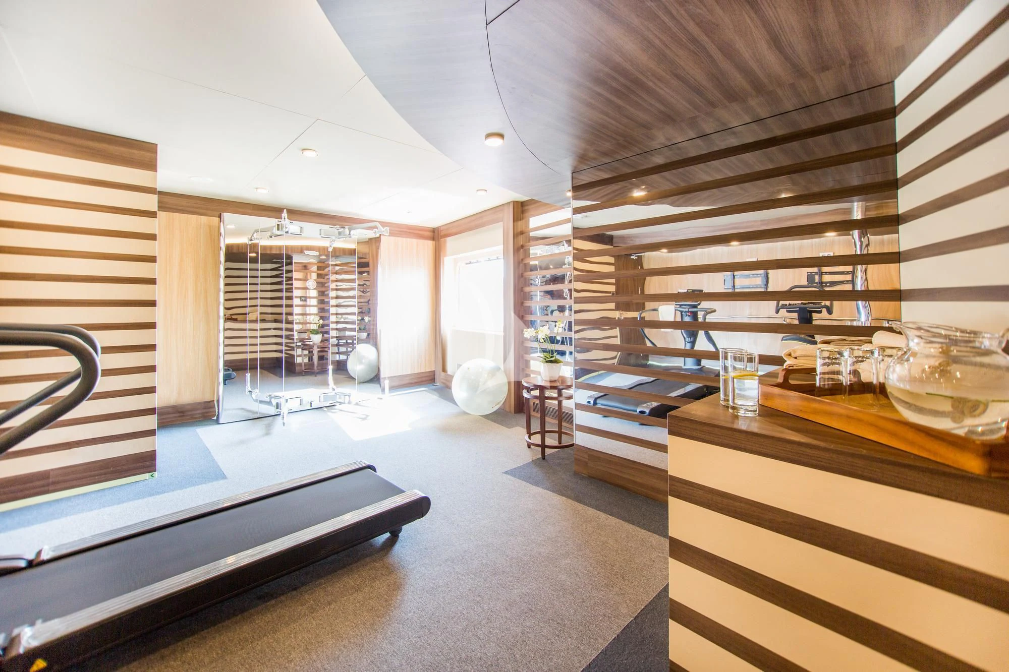 a room with a large window and a table with glasses on it aboard SALUZI Yacht for Charter