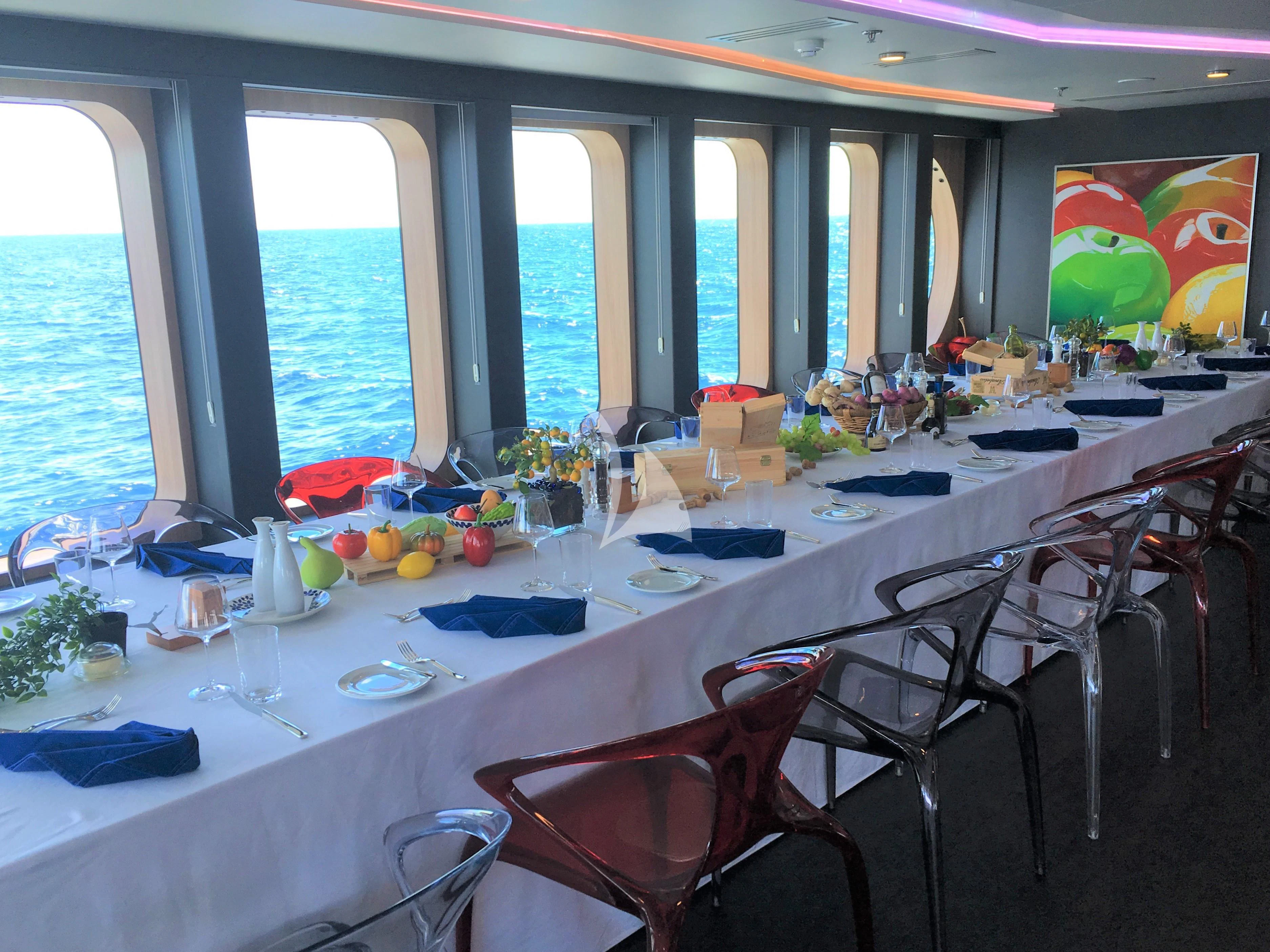 a dining room with a large window aboard SALUZI Yacht for Charter