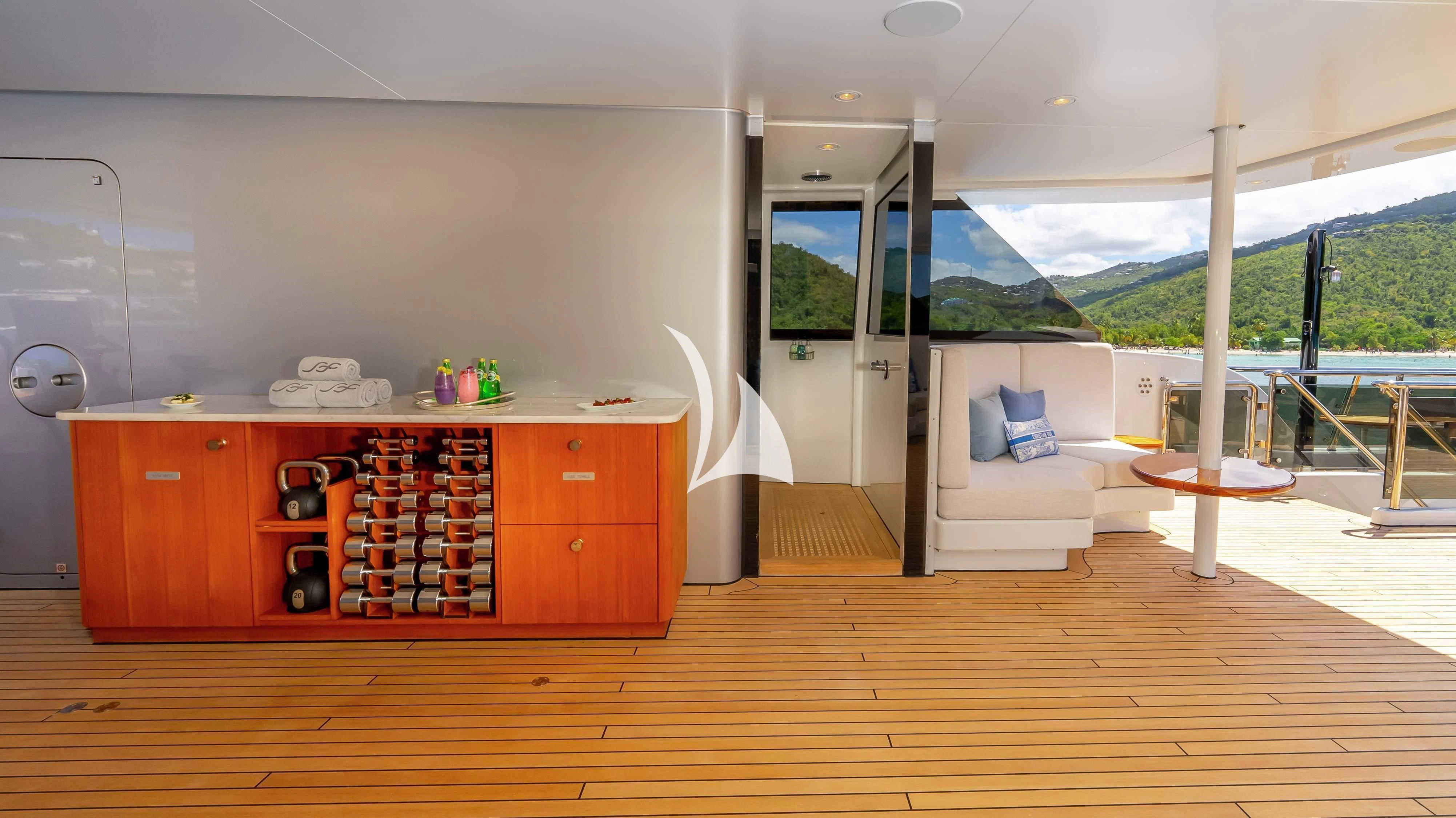 a room with a wood floor and a table with chairs and a window aboard SCOTT FREE Yacht for Charter